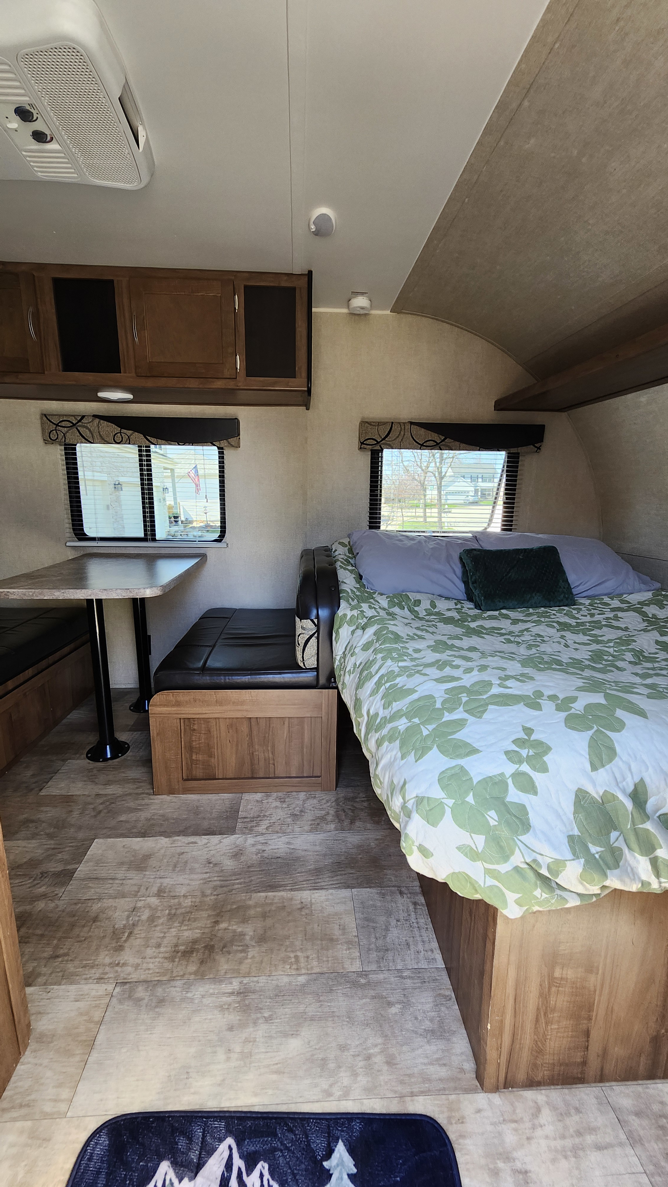 Cozy RV rental interior with a dinette, bed, and storage. Ideal compact living space for road adventures.. Gulf Stream Ameri-Lite Super Lite 2018