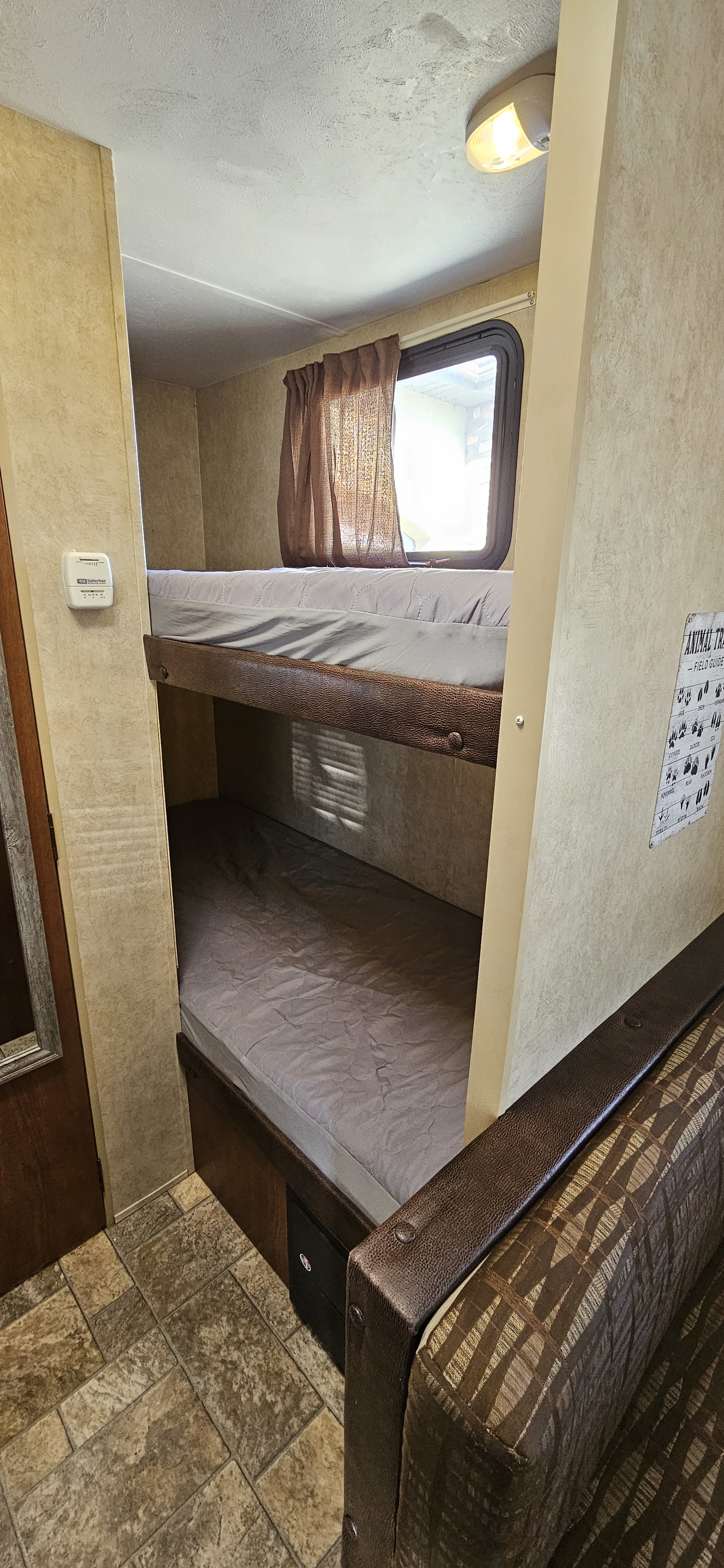 RV rental interior showcasing cozy bunk beds, a window, and a built-in sofa, perfect for comfortable stays.. Forest River Salem Cruise Lite 2015