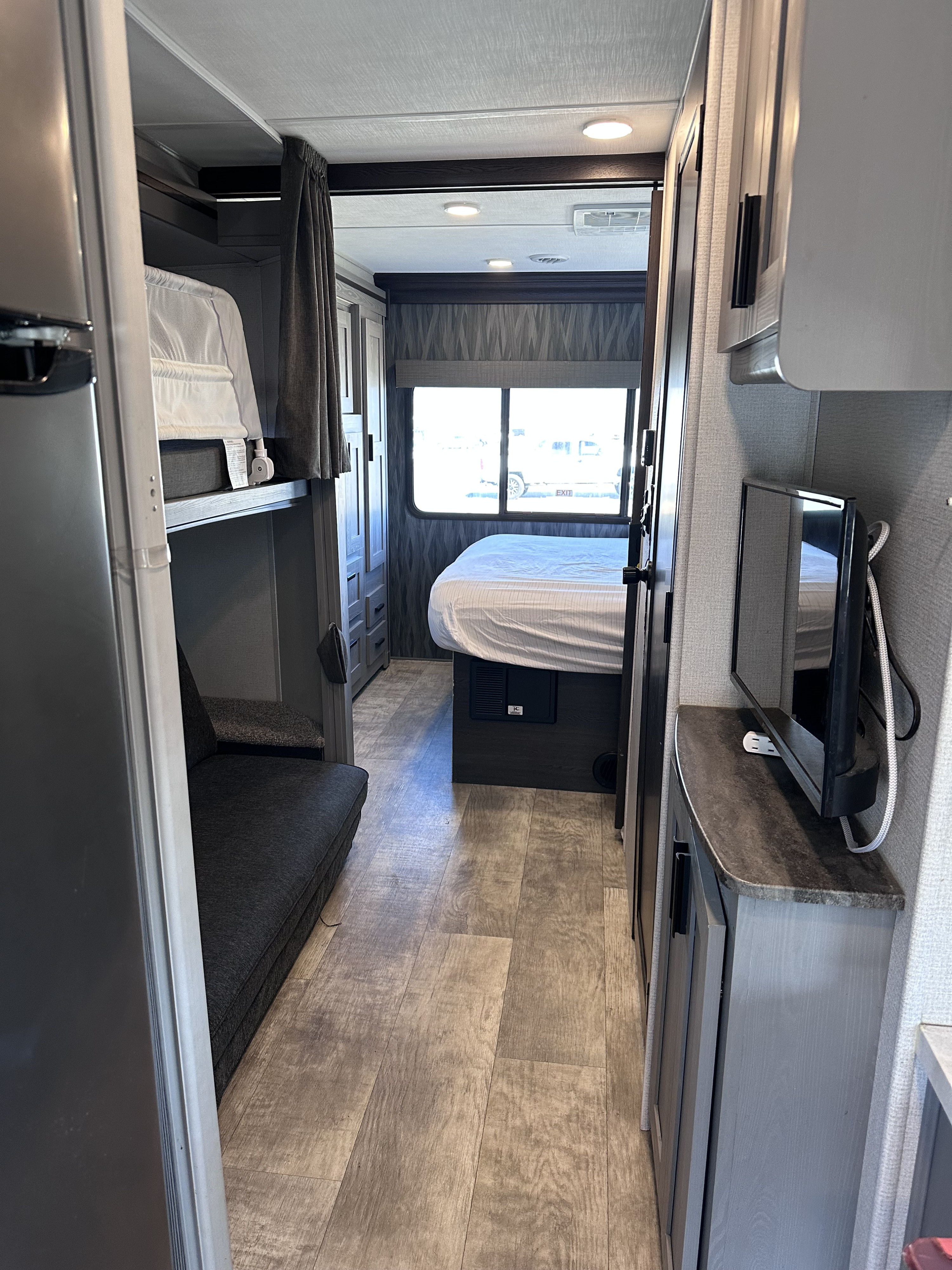 RV rental: Bright, modern interior featuring a primary bedroom at the end of the hall, with bunk beds and TV area.. Forest River Solera 32DSB 2022