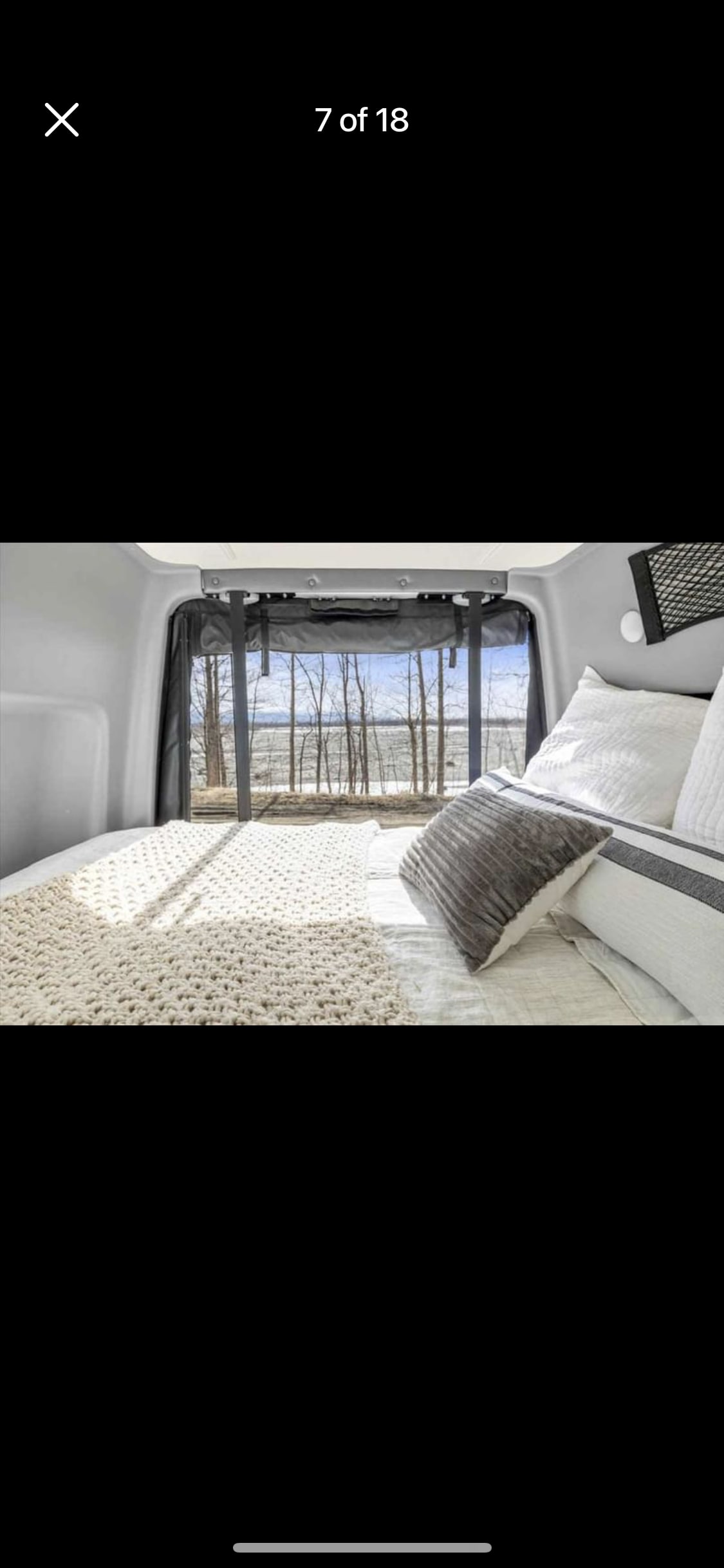 RV rental: Interior shows a cozy bed with white & gray bedding. A large window offers a serene view of bare trees & a winter landscape.. Mercedes-Benz Sprinter RV Motorhome Campervan 2020