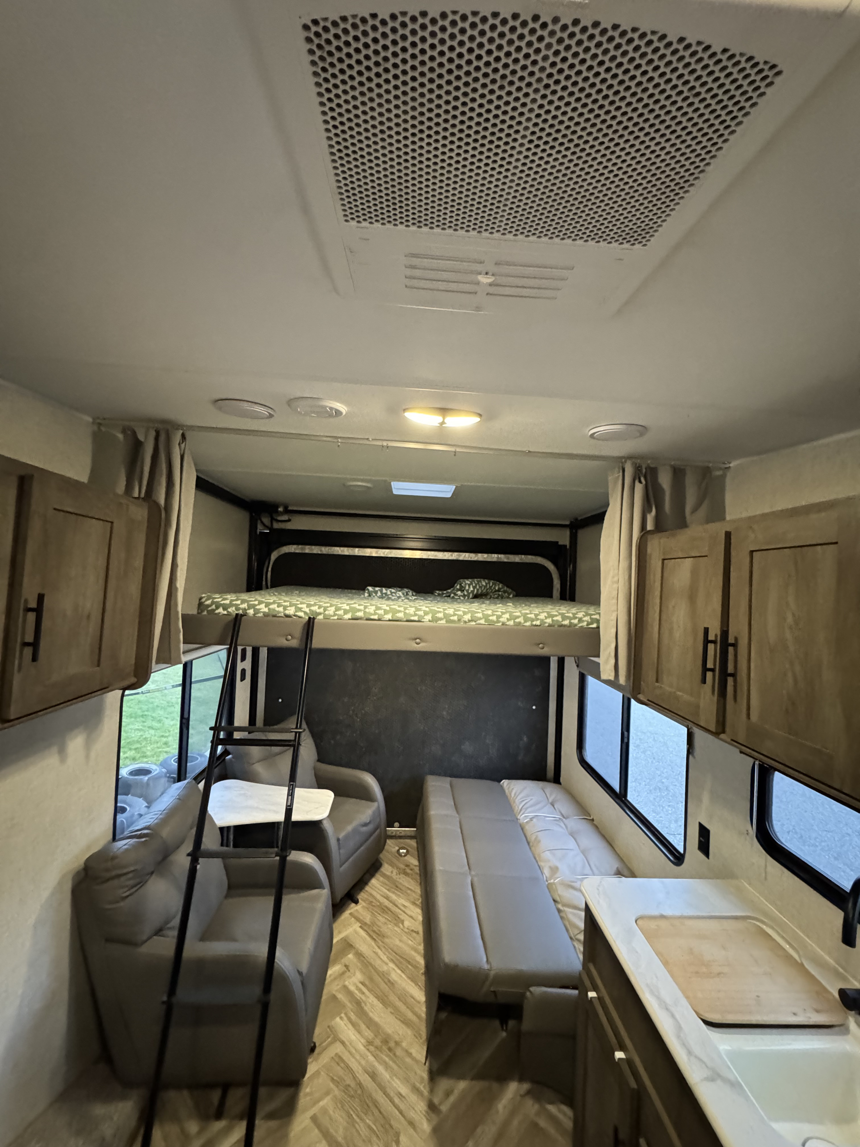 Inside an RV rental: bunk bed, seating, and kitchen for compact, comfortable travel.. Forest River Wildwood 2021