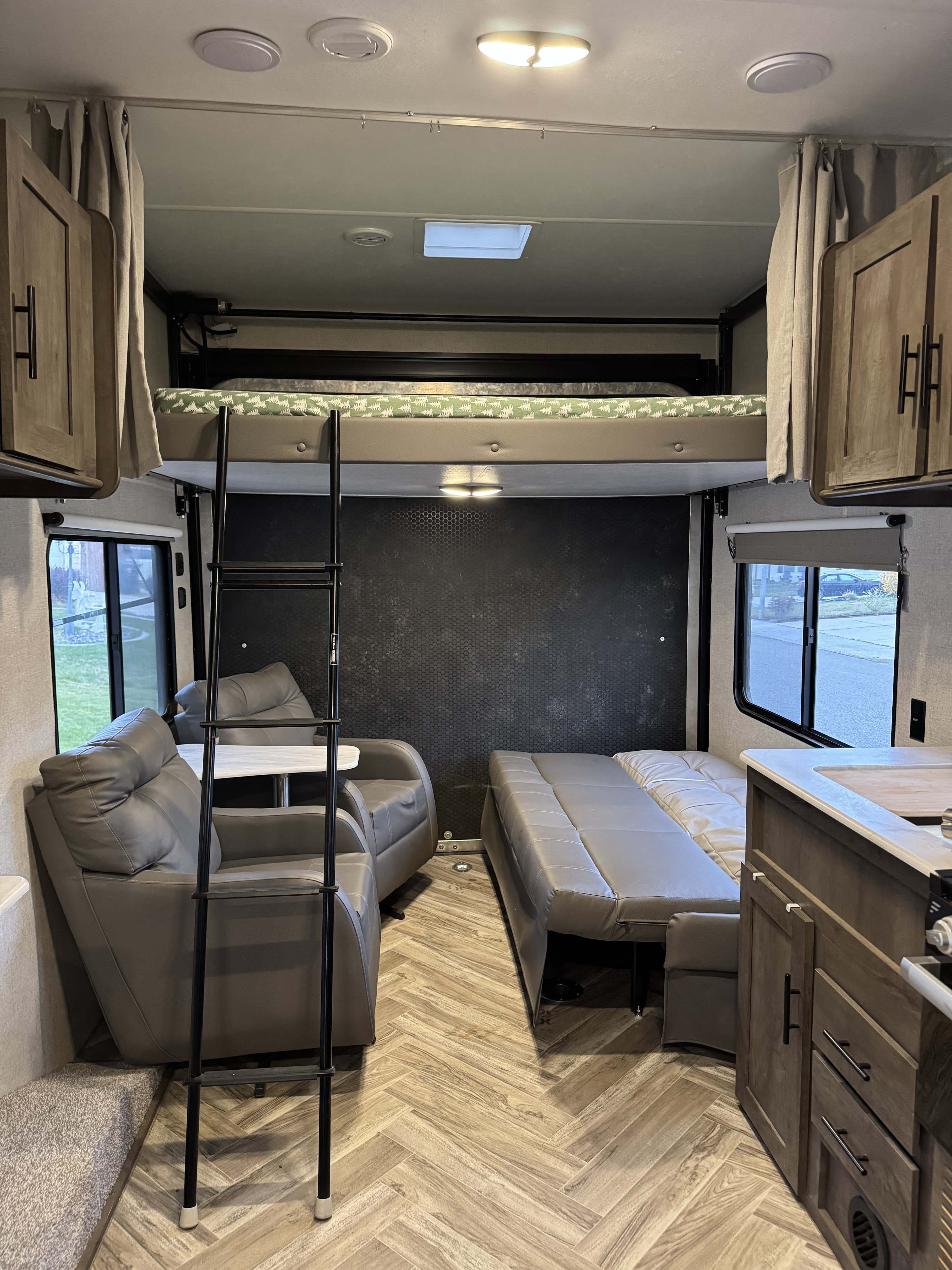 This RV rental features a practical interior with a bunk bed, comfy recliners, convertible sofa, and a kitchen.. Forest River Wildwood 2021
