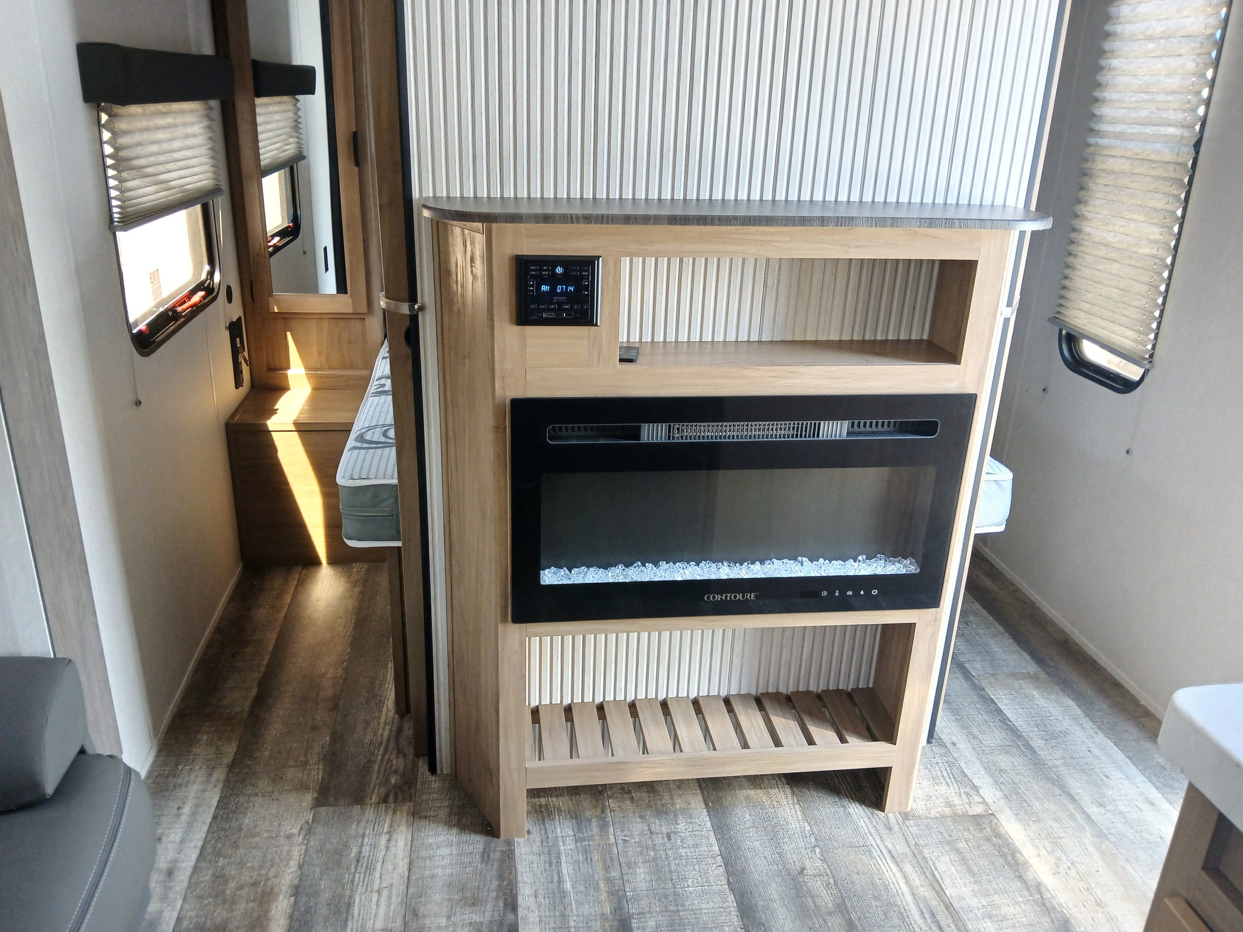 This RV rental's modern interior features a sleek electric fireplace, media control panel, and warm wood tones.. Forest River Cherokee Grey Wolf 2024