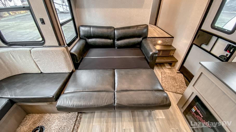 RV rental interior: Versatile living space with a pulled-out sofa bed, comfy dinette, and bright windows.. Forest River Coachmen Chaparral Lite 2022