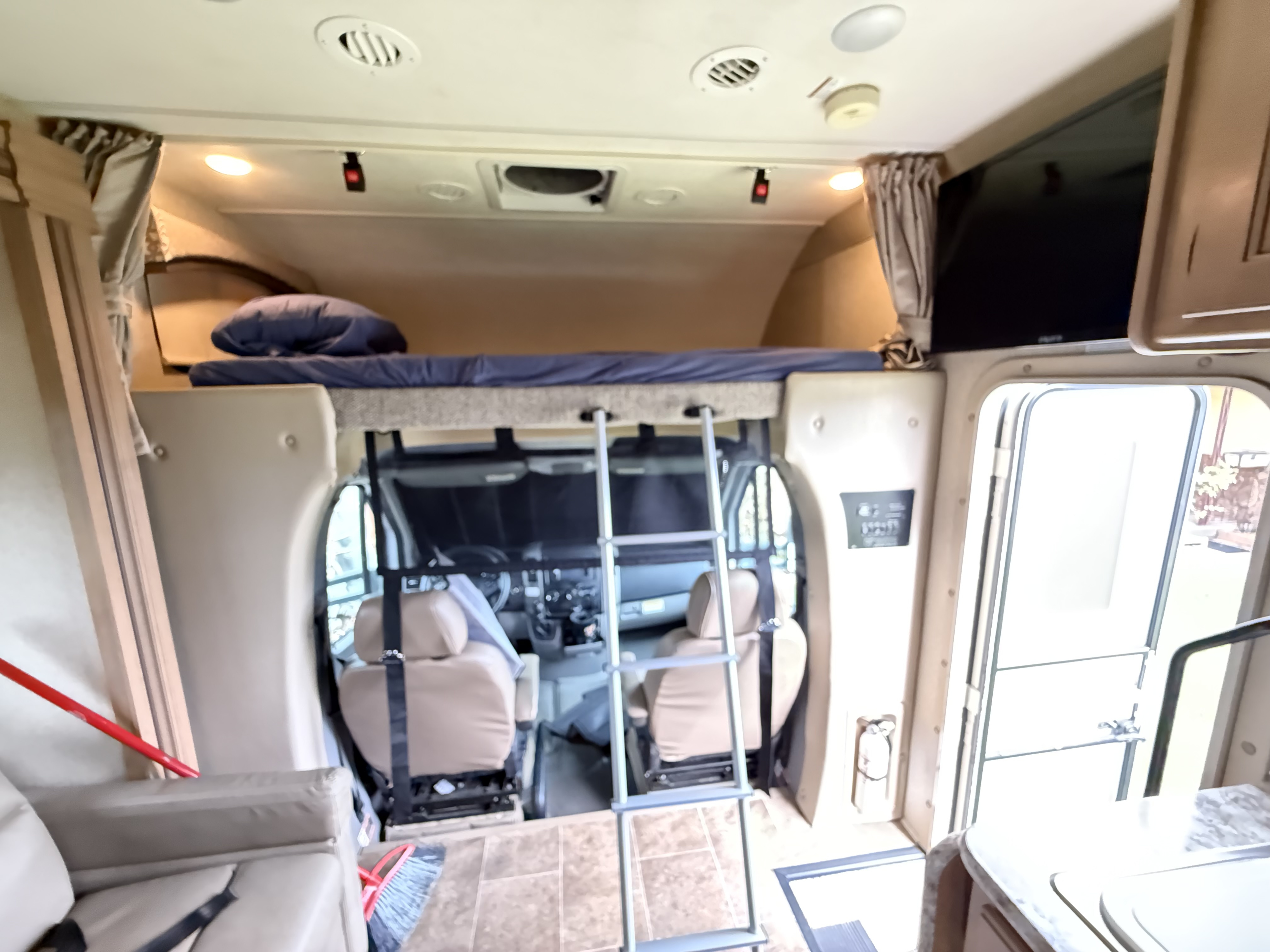 Inside an RV rental: view of the overhead bunk with ladder, driver's cab, and front living area for your adventures.. Thor Chateau Sprinter 2018