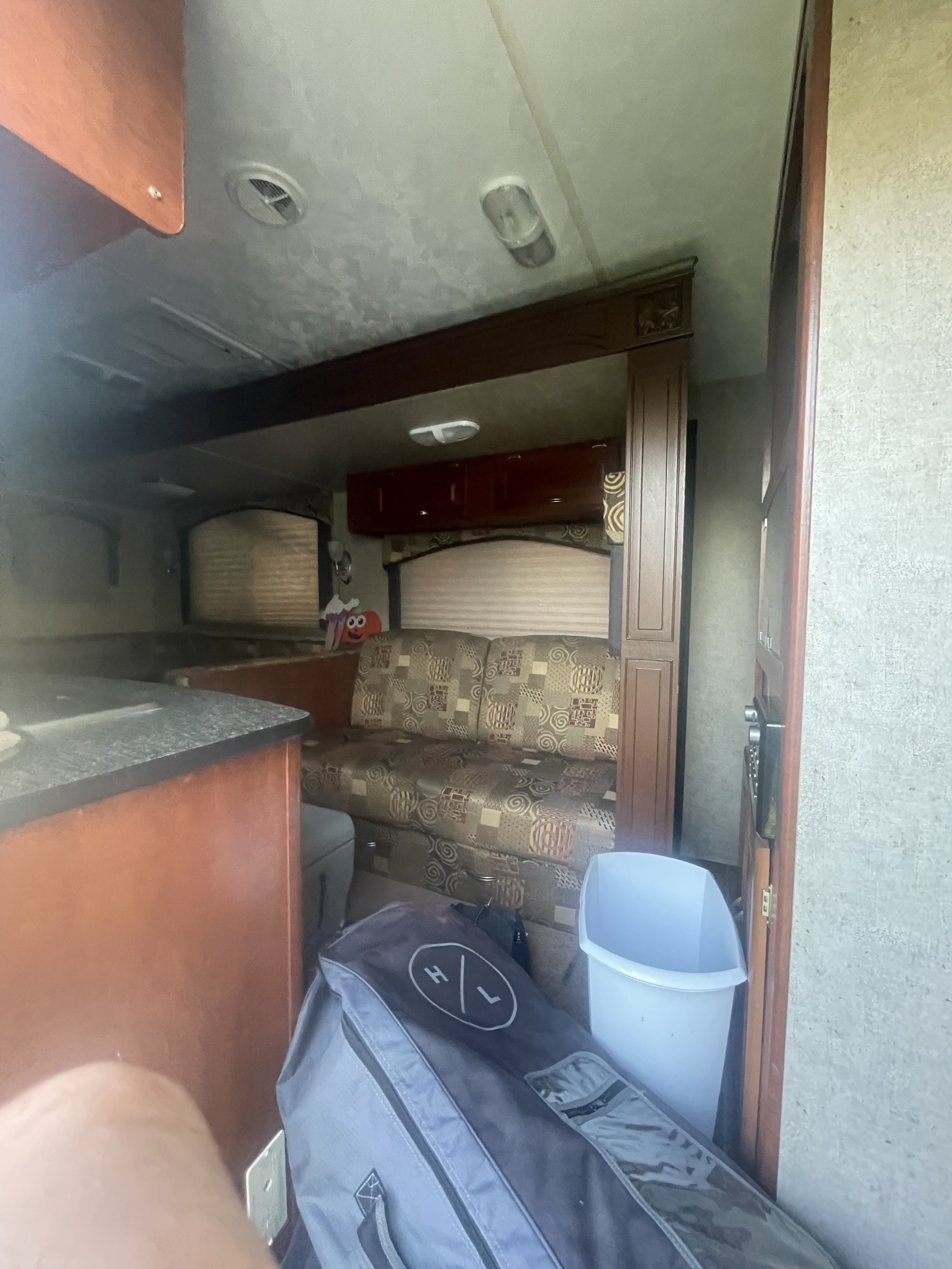 Step inside this RV rental, showcasing a comfortable patterned sofa, wooden cabinets, and a functional counter space.. Forest River Wildwood 2012