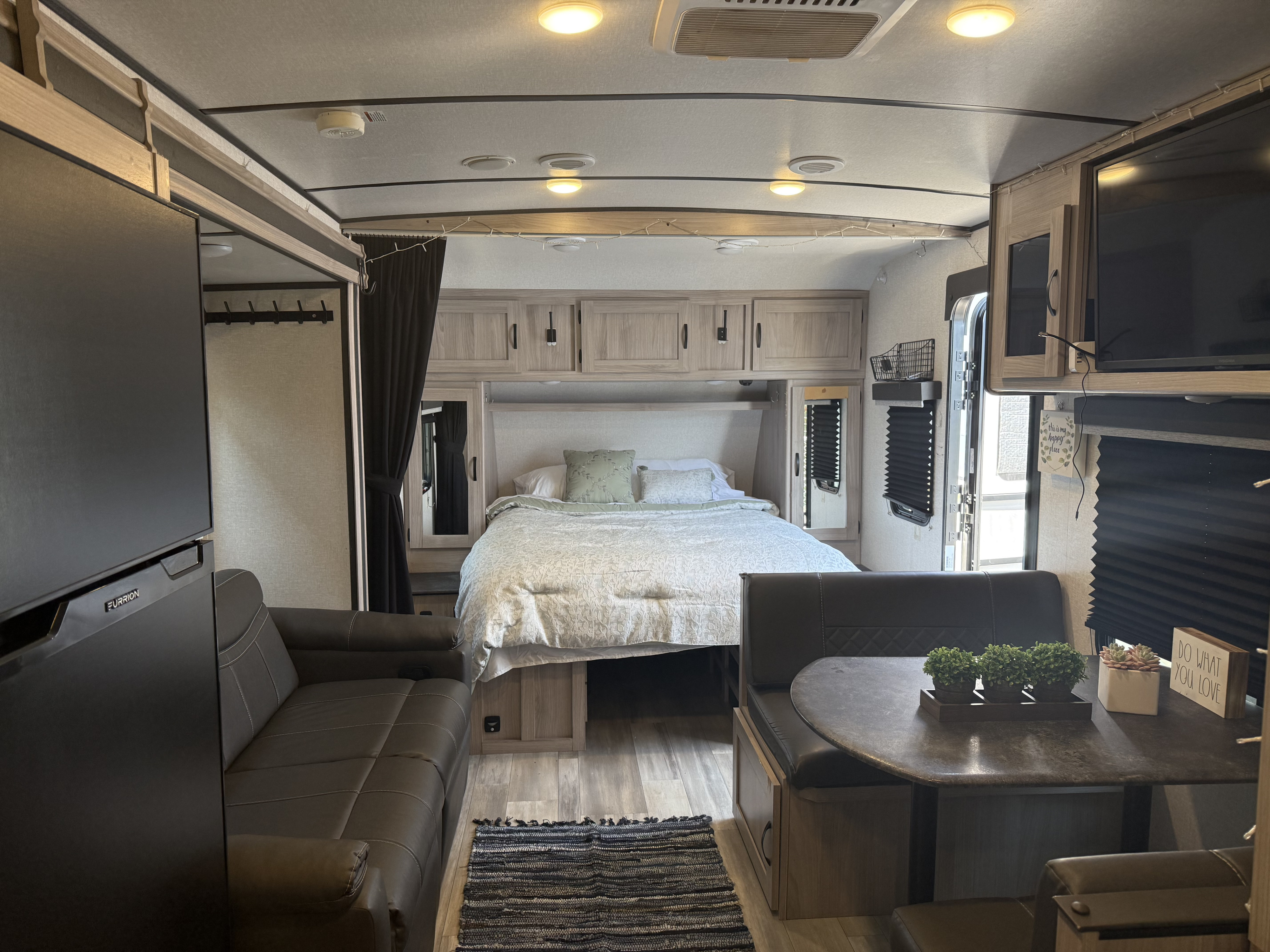 Bright RV rental interior featuring a cozy bedroom, spacious living area with sofa, and dining nook, perfect for travel.. Forest River Coachmen Northern Spirit Ultra Lite 2023