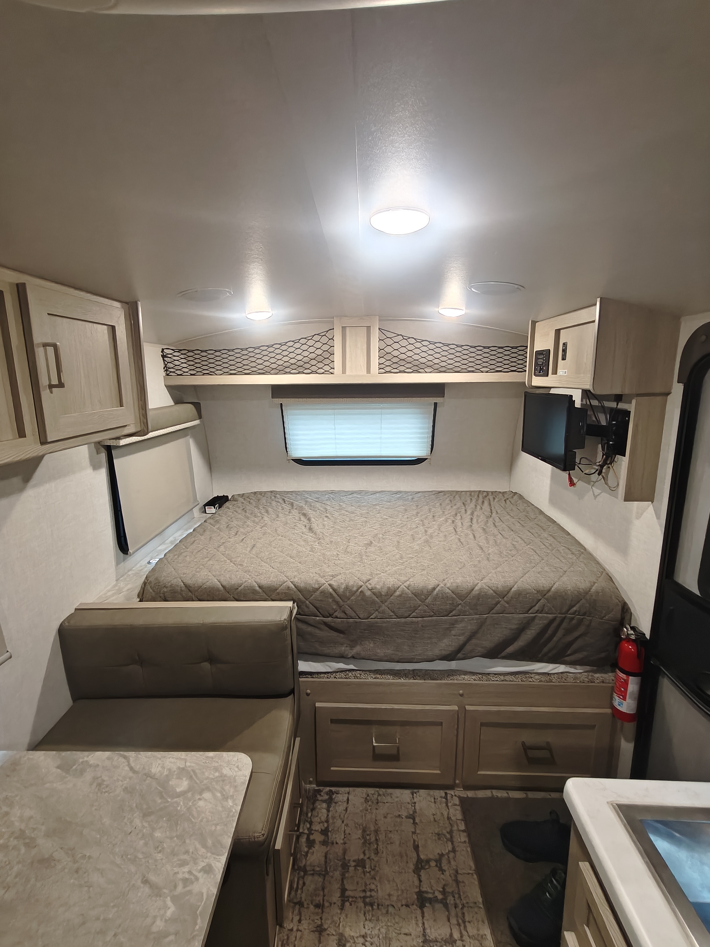 Experience RV rental comfort! This compact camper interior features a cozy bed, dinette, and storage, ideal for travel.. Geopro 19Bh 2021