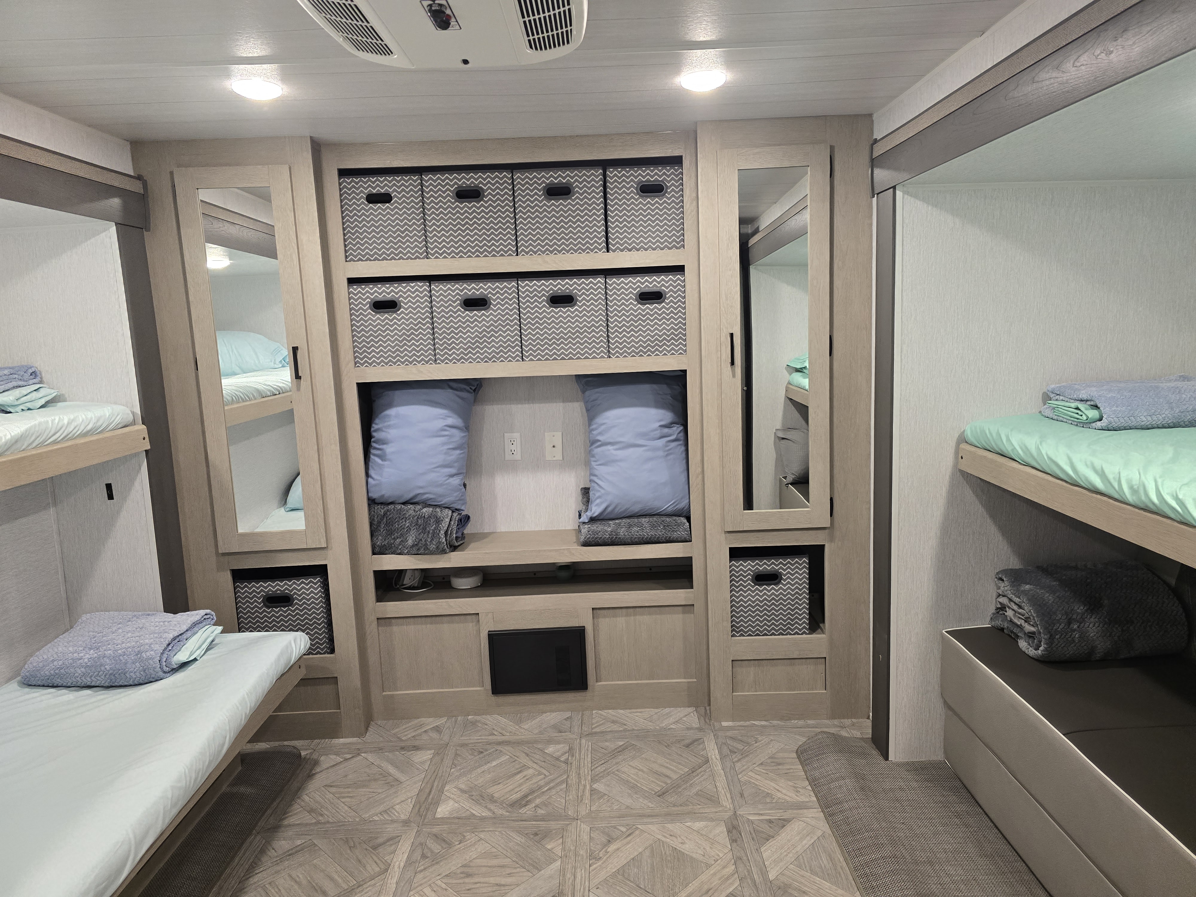 Functional RV rental interior with multiple bunk beds, bedding, and practical built-in storage units for a comfortable stay.. Forest River Salem Platinum 2024
