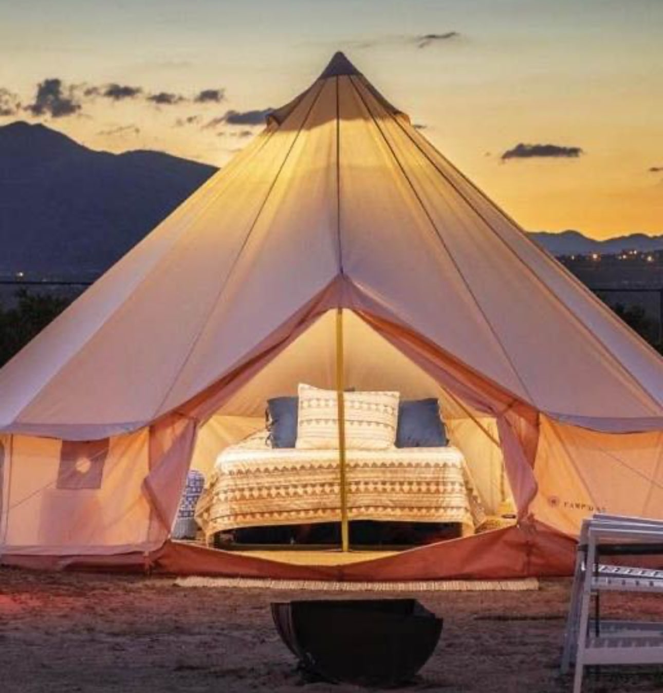 This image shows a beautifully lit bell tent with a comfortable bed, perfect for glamping at sunset. Ideal for an RV rental getaway.. Keystone RV Springdale 2019