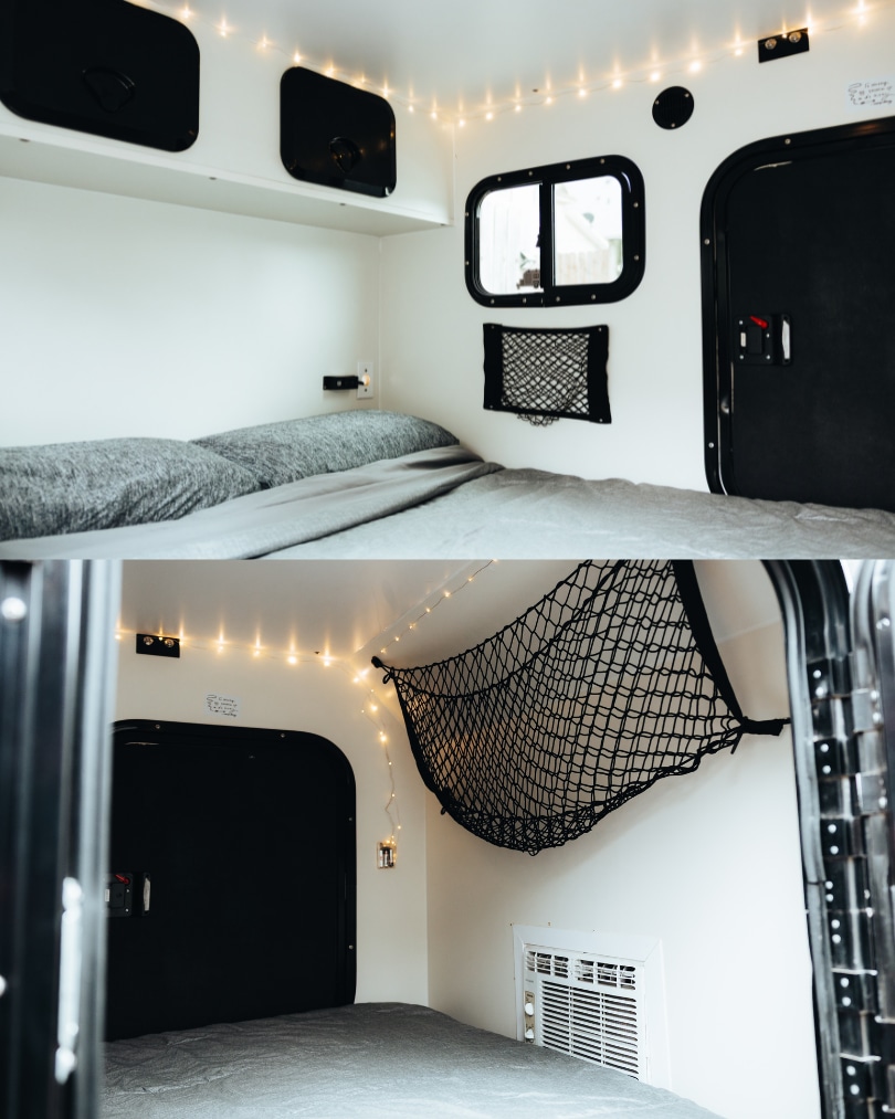 Cozy RV rental interior: a bed with gray bedding, string lights, windows, and storage nets create a warm, functional space.. Other Other 2022