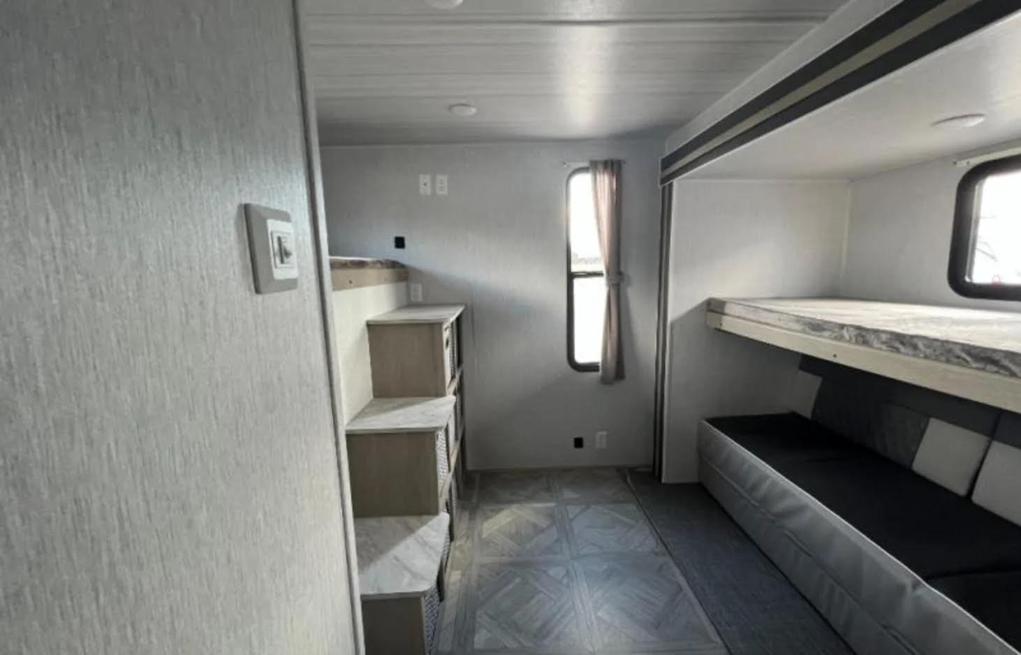 Spacious RV rental interior with a bunk bed area over a sofa, and built-in storage for comfortable travel.. Forest River Salem Cruise Lite 2023