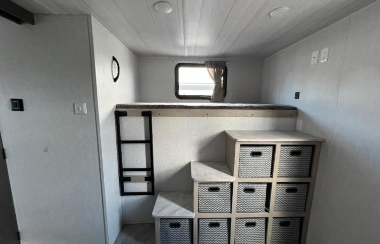 RV rental interior: cozy bunk bed setup with ladder, window, and integrated storage cubbies and baskets.. Forest River Salem Cruise Lite 2023
