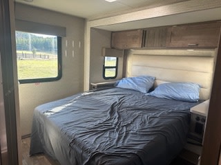 This queen-sized bed is brand new! We also have storage above the bed and charging ports. There is also a TV on the wall not in picture. . Winnebago Minnie Winnie 2022