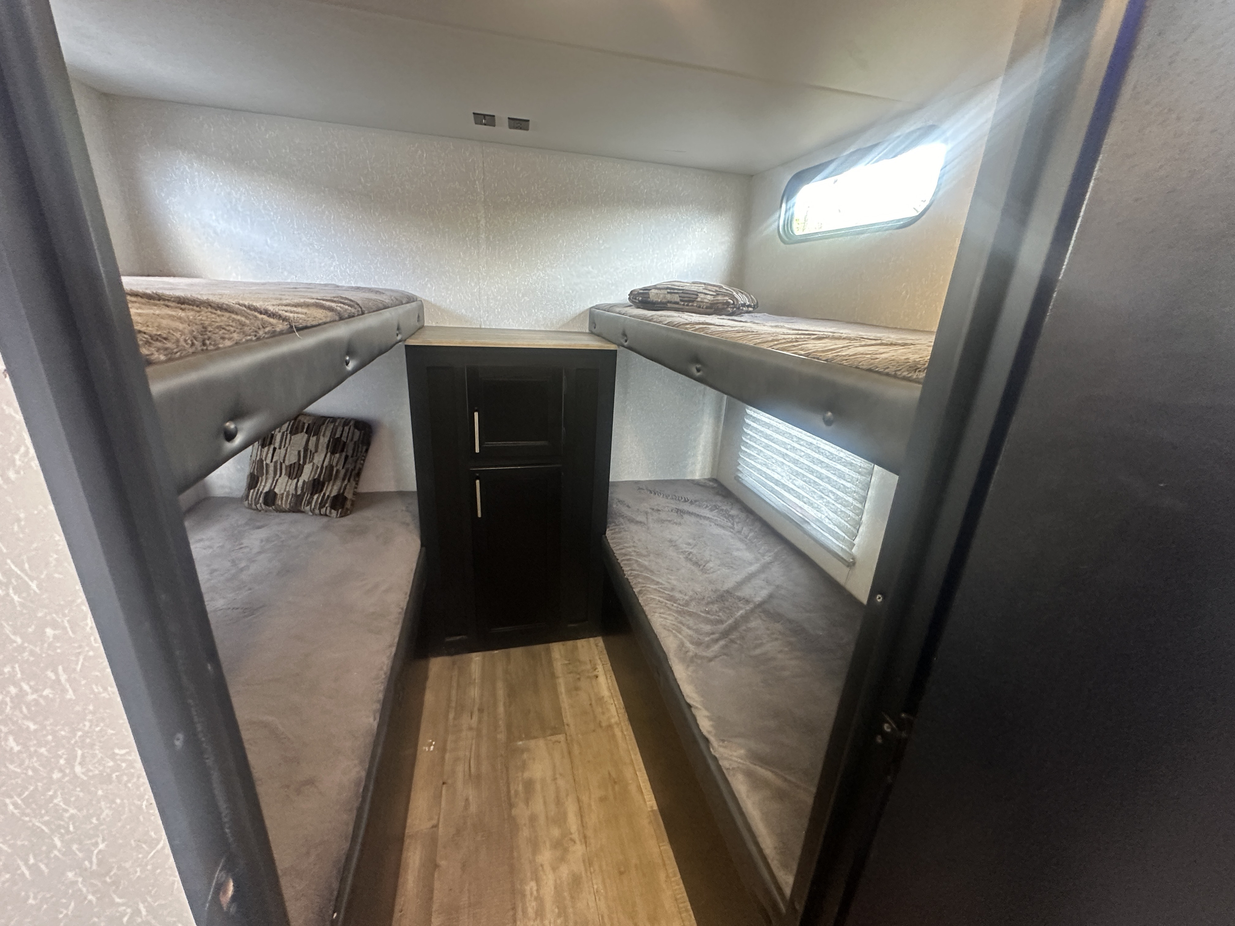 This RV rental features a comfortable bunkhouse area with four beds and storage.. Forest River Cherokee Grey Wolf 2022