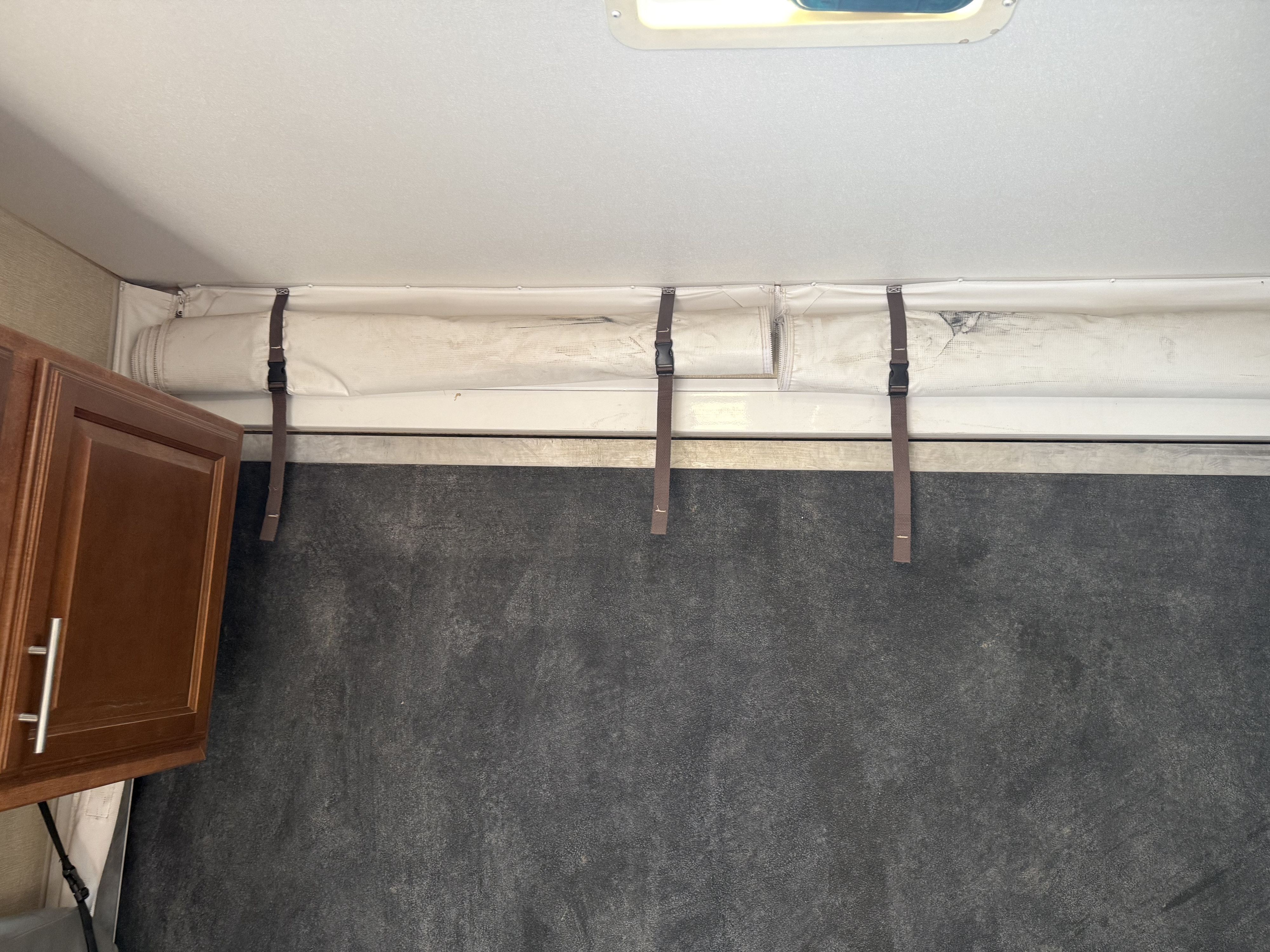 RV rental: Toy hauler interior showing a bed rolled up and strapped to the ceiling, above a textured black floor.. Eclipse Recreational Vehicles Attitude 2013