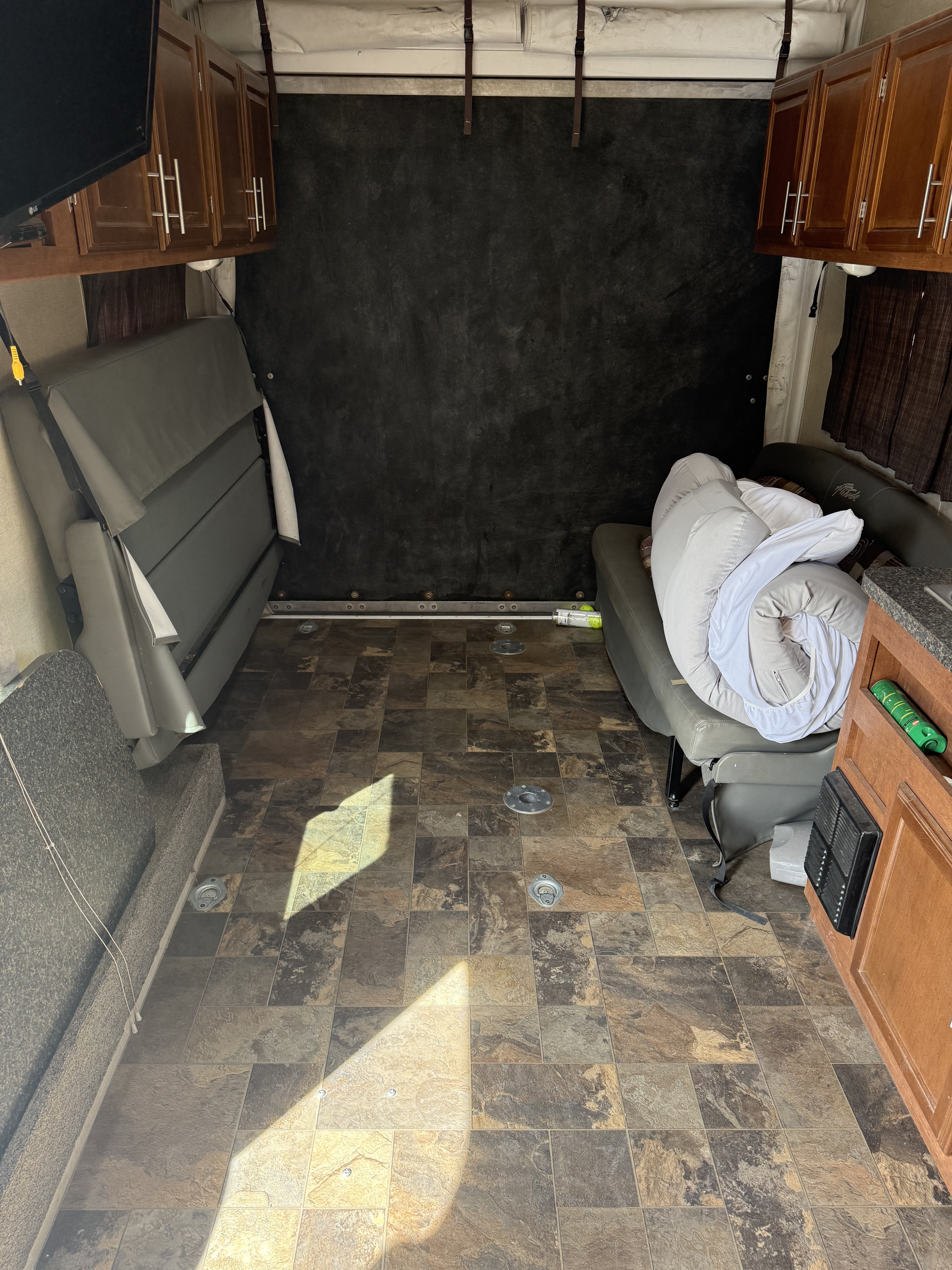 RV rental interior: Spacious toy hauler with fold-up beds, cabinets, and durable flooring, ideal for versatile use.. Eclipse Recreational Vehicles Attitude 2013