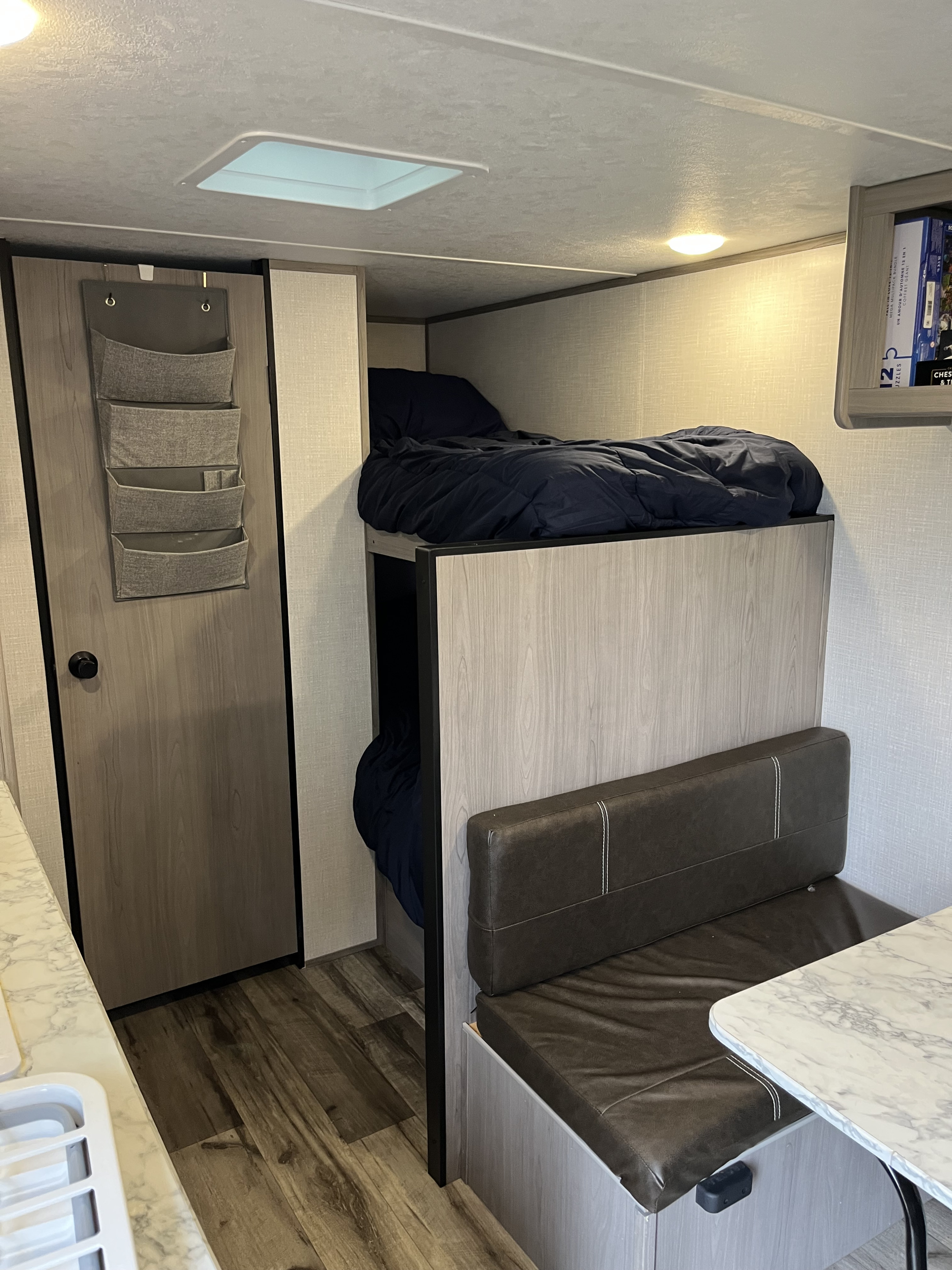 Cozy rv rental interior with bunk beds, dining booth, and organizational features. Perfect for families on the go.. Dutchmen Coleman Lantern LT 2023