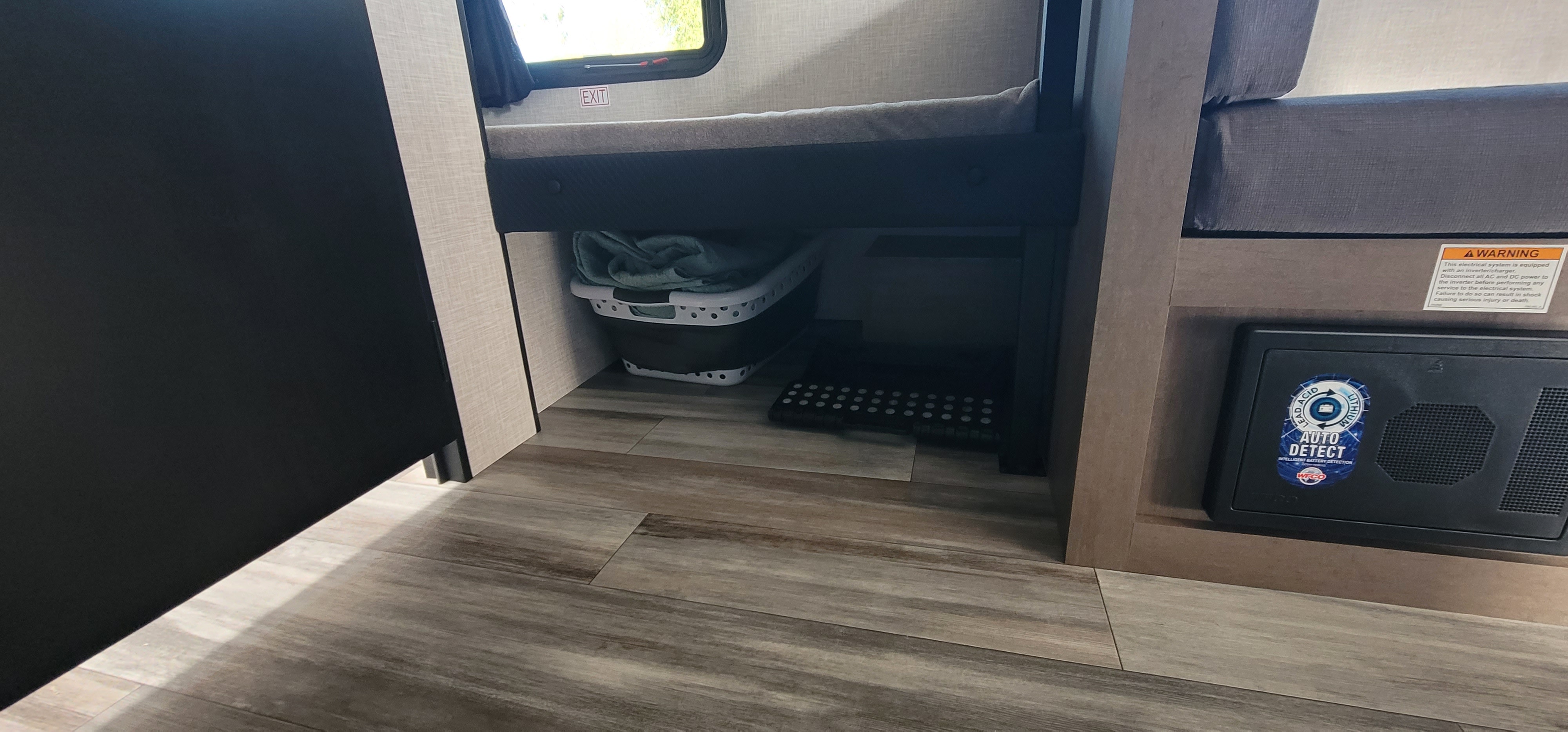 View inside an RV rental, highlighting a bunk bed with under-bed storage and an accessible electrical control panel.. Jayco Jay Flight SLX 2025