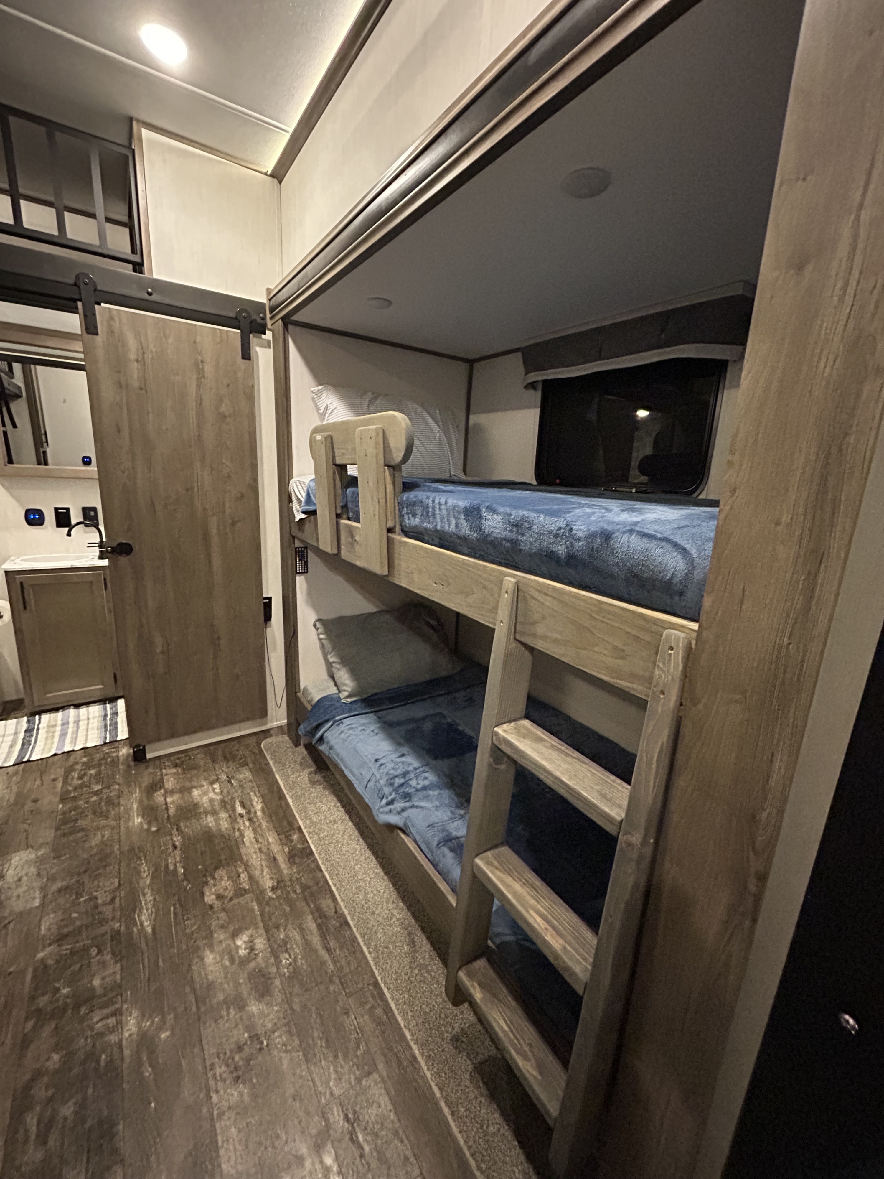 RV rental: Compact bunk beds with ladder & vanity area, separated by a barn door.. Forest River Sabre 2022