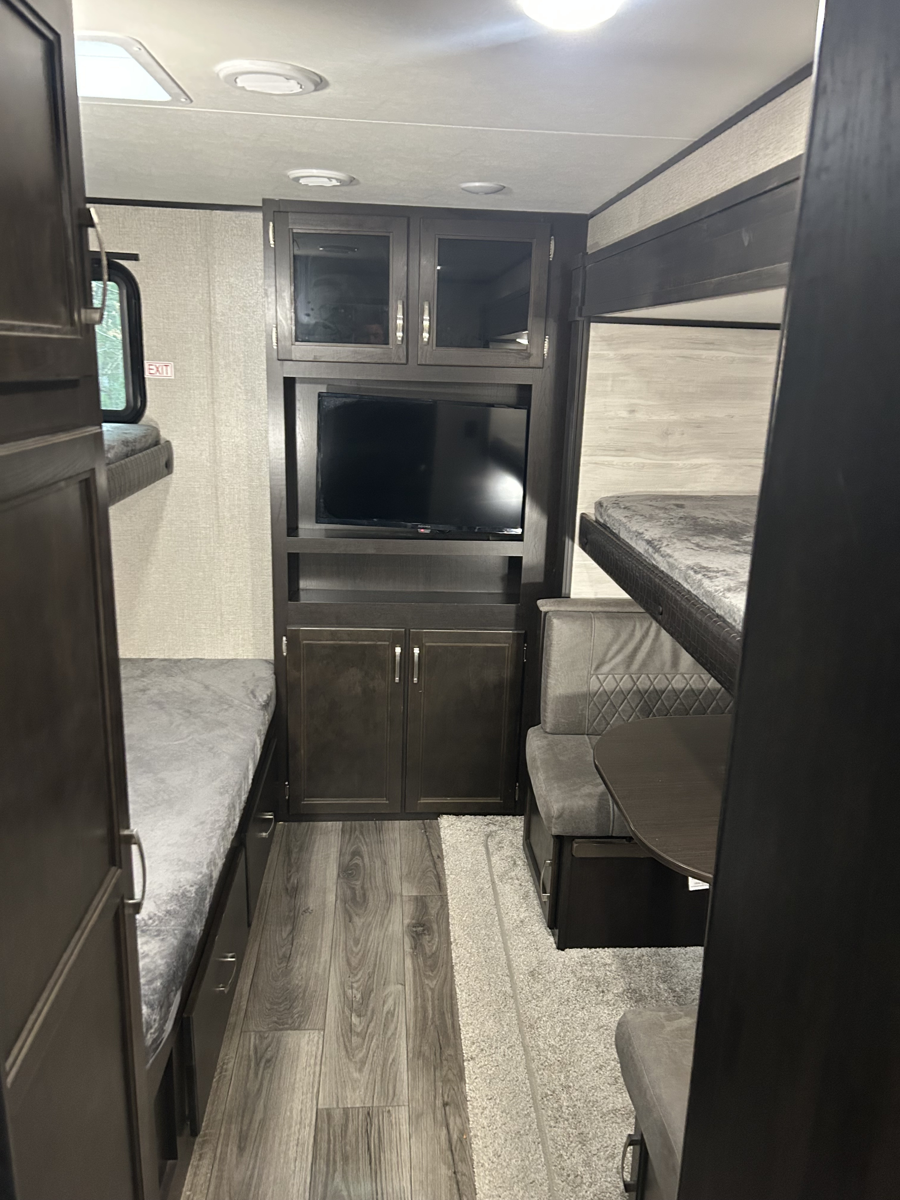 Spacious RV rental interior featuring comfortable bunk beds, a central TV, and a dining area.. Jayco Jay Flight 33RBTS 2023