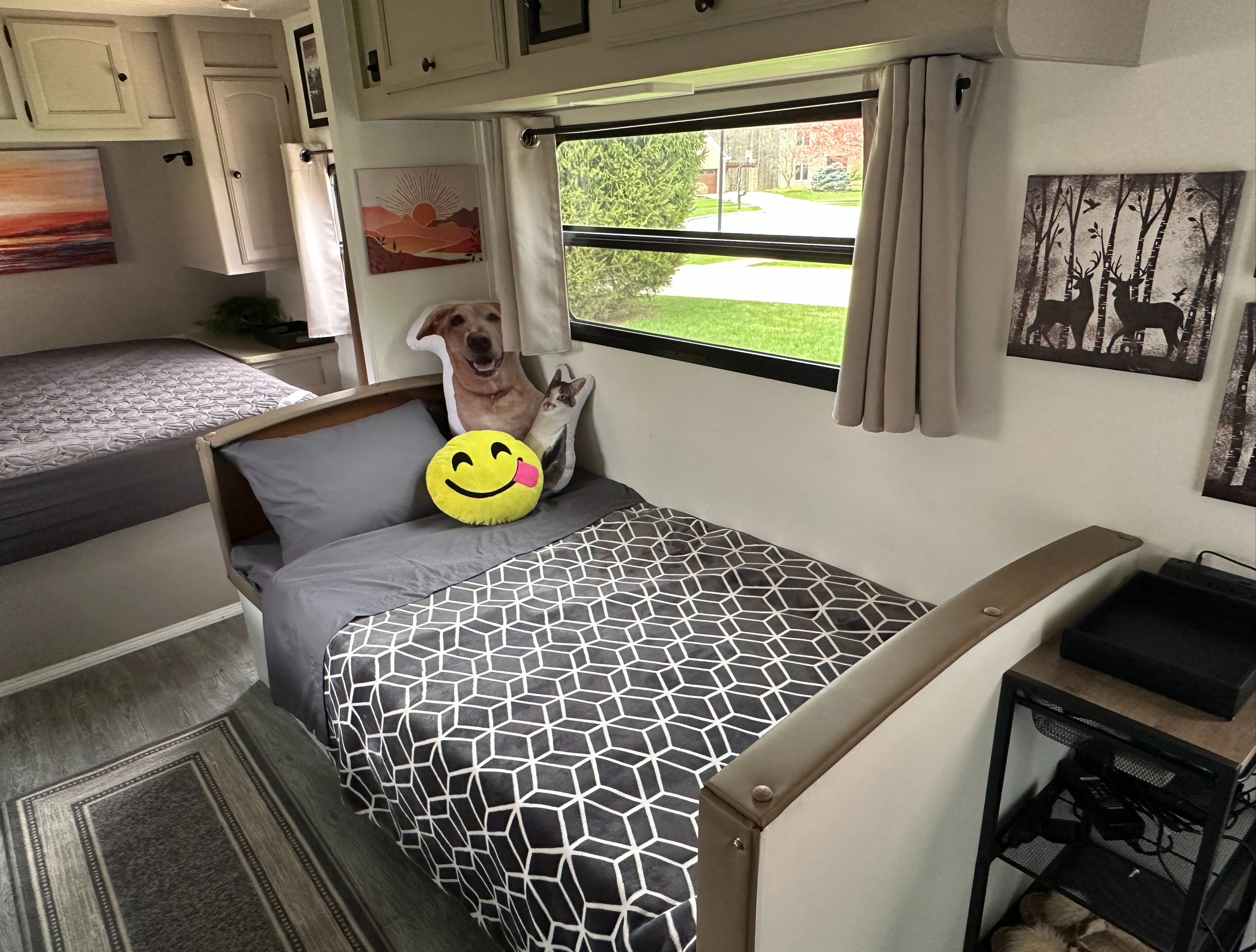 Bright RV rental interior showing two cozy beds, one with a geometric blanket & fun pillows, plus outdoor views.. Gulf Stream Stream Lite Sport 2011