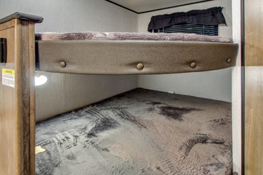 RV rental interior: Two sturdy bunk beds. The lower bunk, with scuff marks, is versatile for sleeping or equipment storage.. Heartland RVs Pioneer 2022