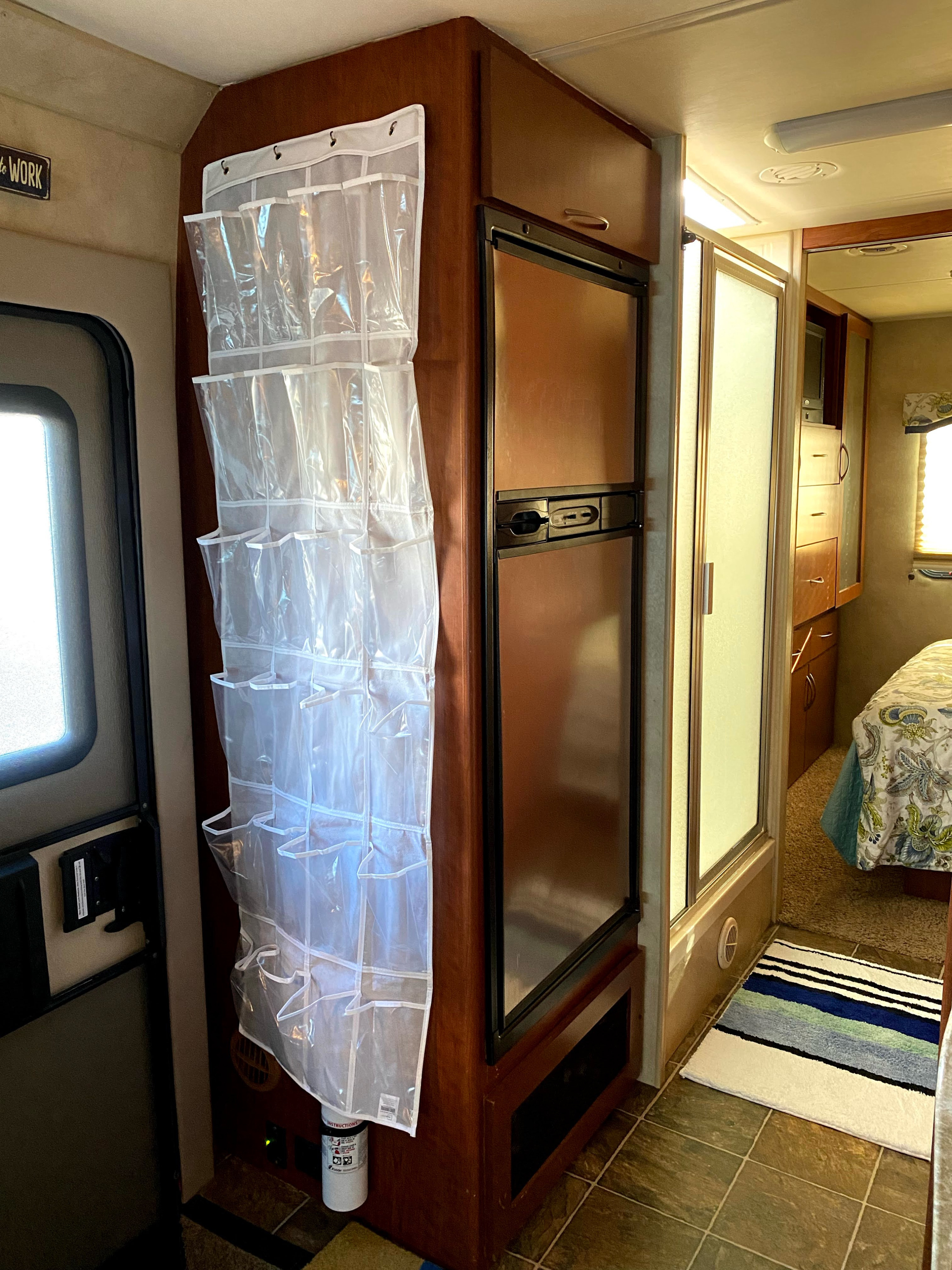RV rental interior shows clever shoe organizer next to fridge, shower, and bedroom, maximizing space in a camper.. Four Winds Chateau Citation 2011