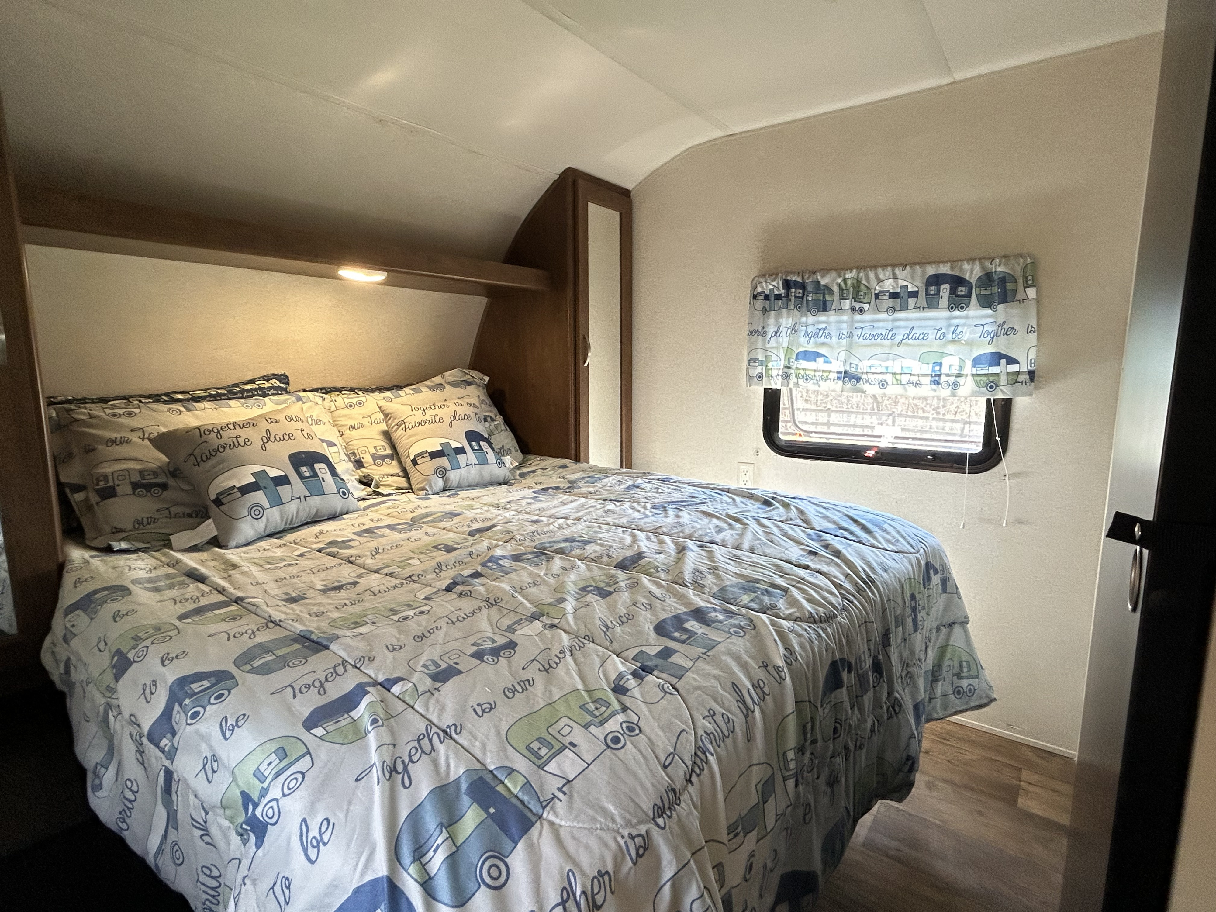 Cozy RV rental bedroom with camper-themed bedding and "Together is our favorite place to be" pillows.. Forest River Salem 2017