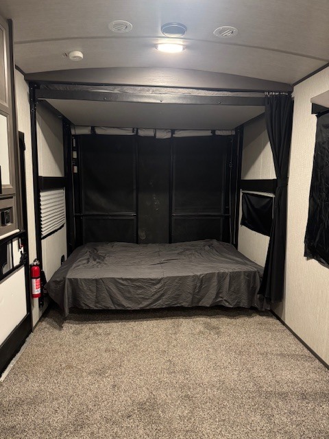 RV rental: Toy hauler interior with a drop-down bed, carpeted floor, and fire extinguisher on the left.. Cruiser Rv Corp Stryker 2020