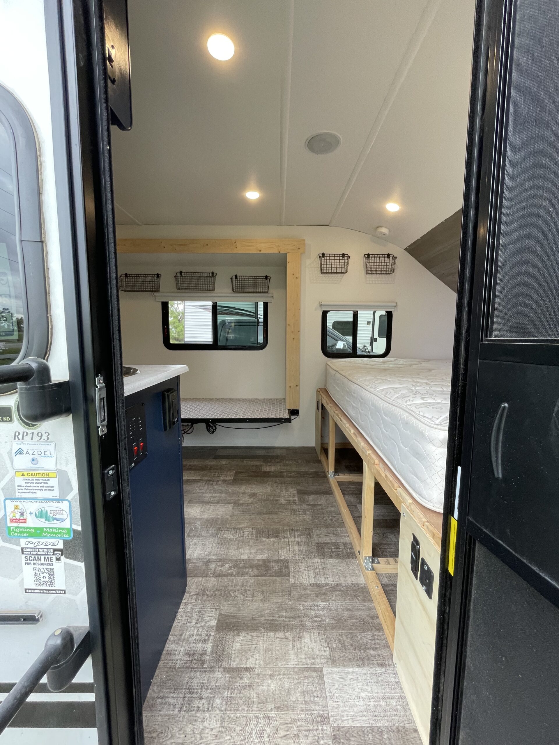 Explore this compact RV rental interior with a galley counter, sleeping areas, overhead lighting, and storage baskets.. Forest River R Pod 2022