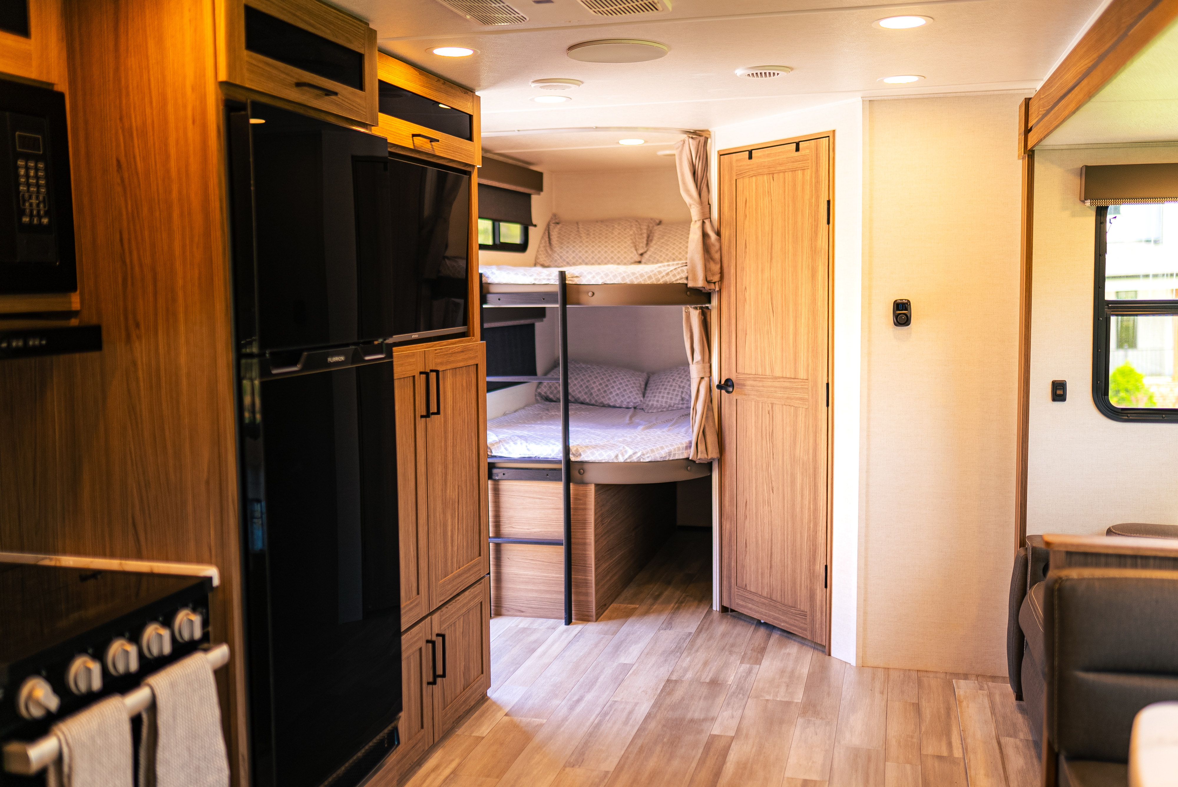Bright RV rental interior featuring a wood-paneled kitchen, bunk beds, and a comfortable living space.. Alliance Delta 281BH 2024