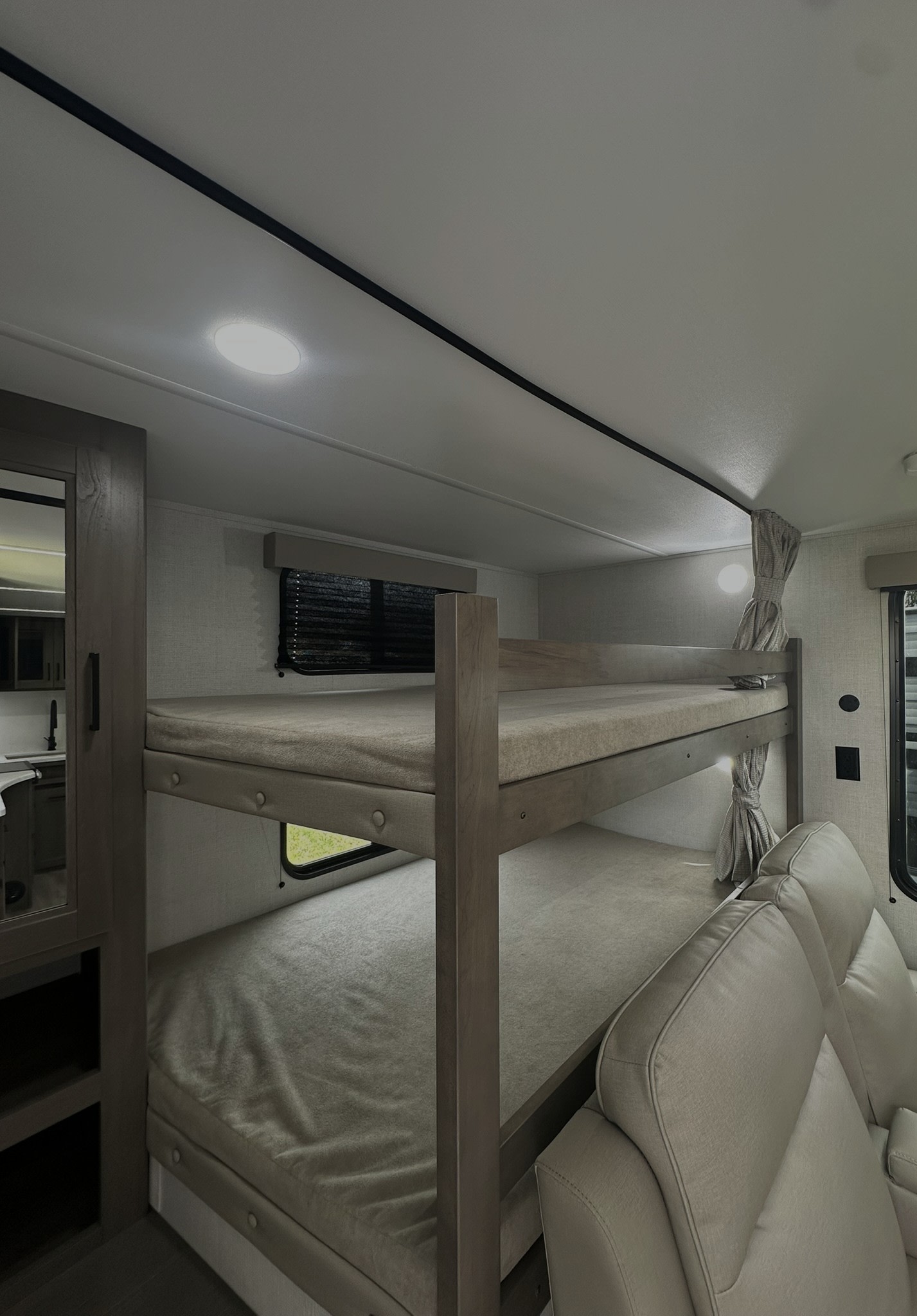 Spacious RV rental: Interior shows bunk beds, kitchen nook, and comfy seating. Perfect for family adventures.. Grand Design Transcend Xplor 2025