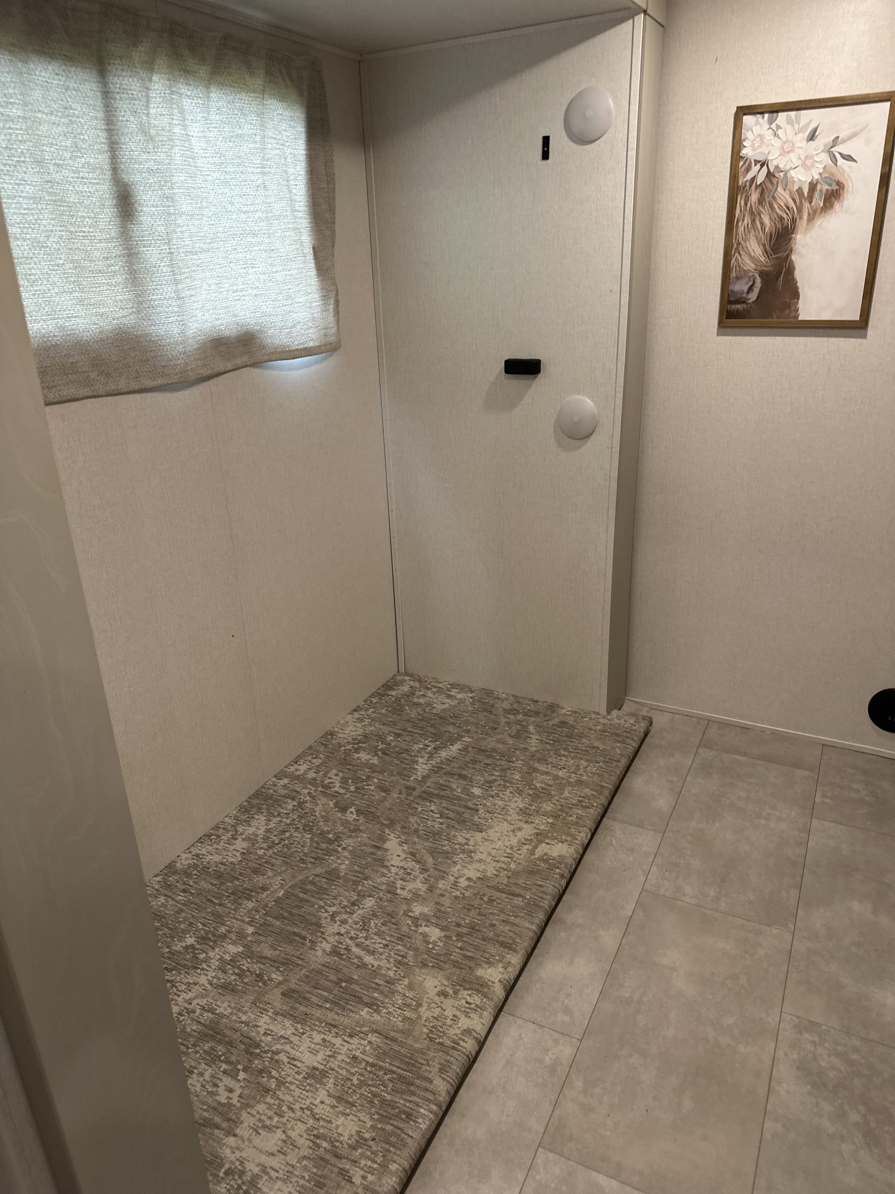 RV rental interior: window, door, patterned rug to tiled floor, and framed Highland cow art.. Forest River Palomino Columbus C 2022
