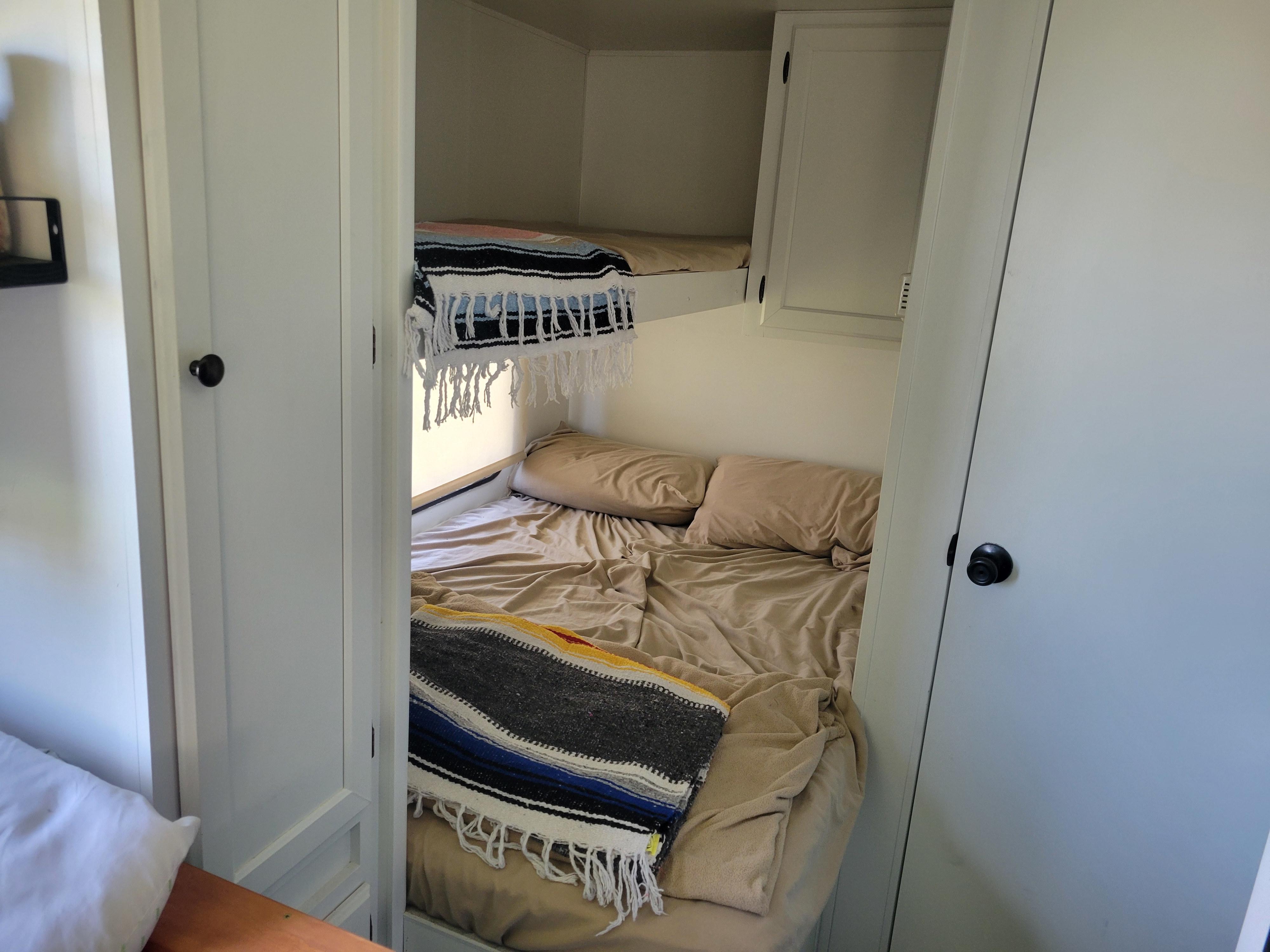 Cozy RV rental bunk beds: two compact sleeping areas with blankets & pillows, ideal for a family adventure.. Dutchmen Weekender 2010