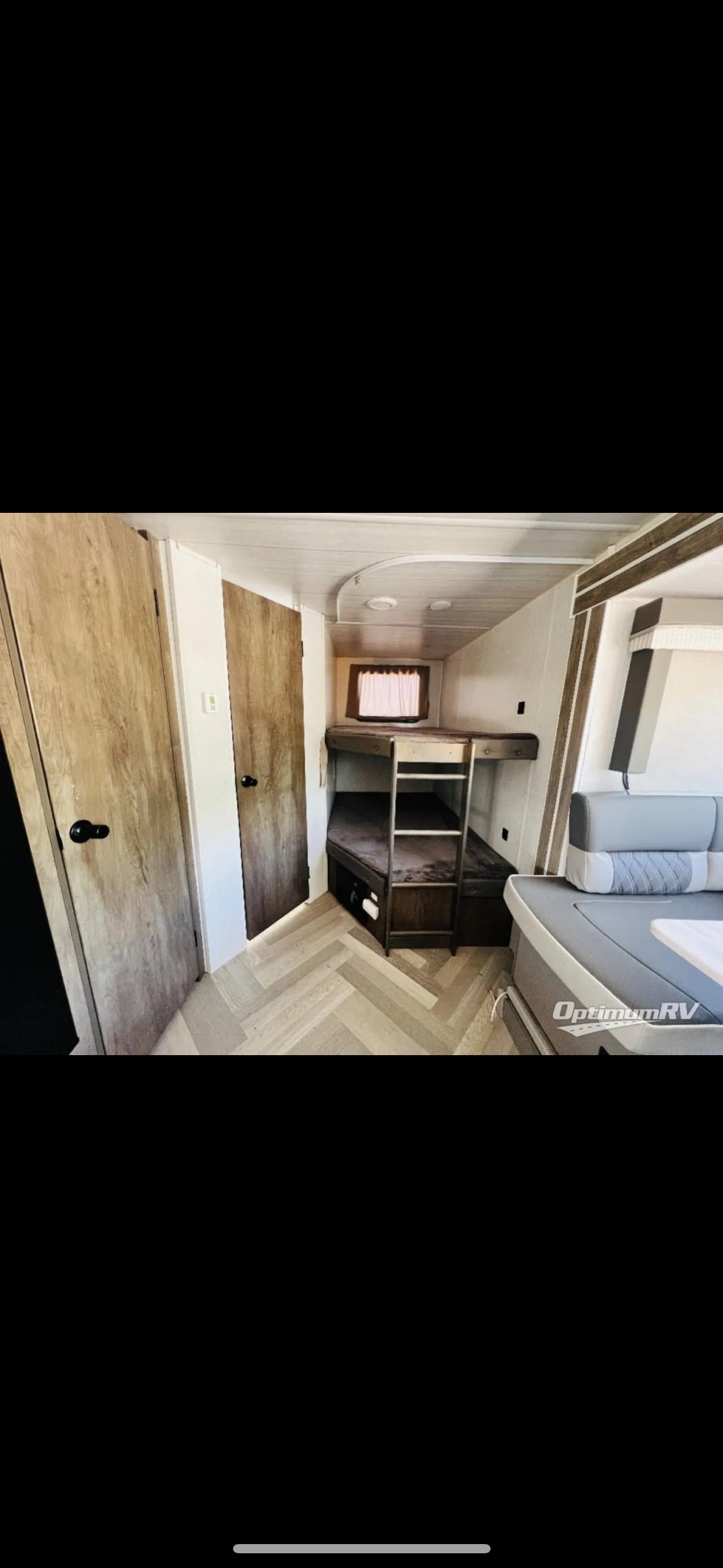 Cozy RV rental interior with bunk beds, dinette, and modern wood-look flooring, perfect for family adventures.. Forest River Wildwood X-Lite 2022
