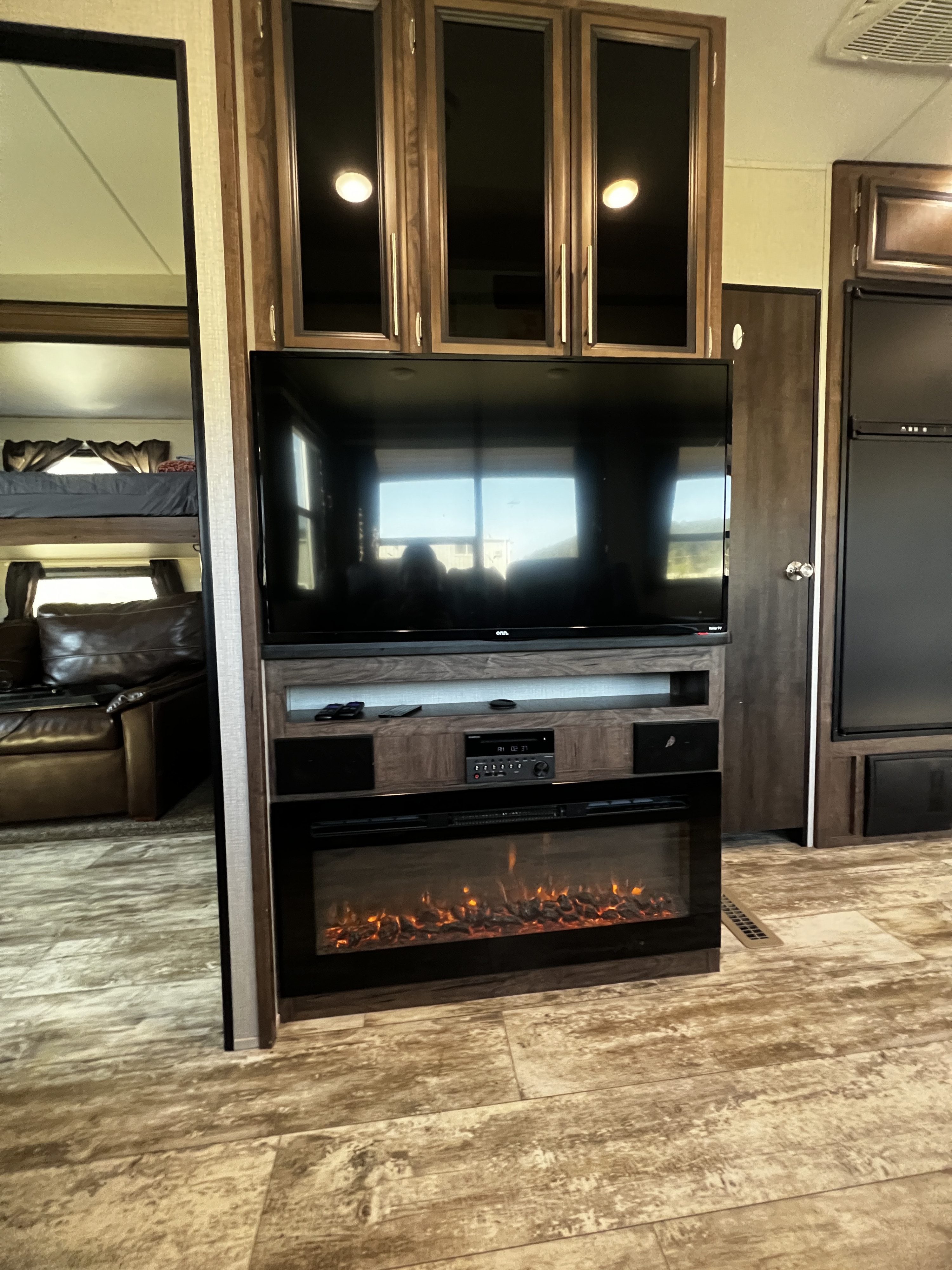 Step inside this RV rental's cozy living space with a large TV, entertainment center, fireplace, and bunk beds.. K-Z Manufacturing Durango 2020