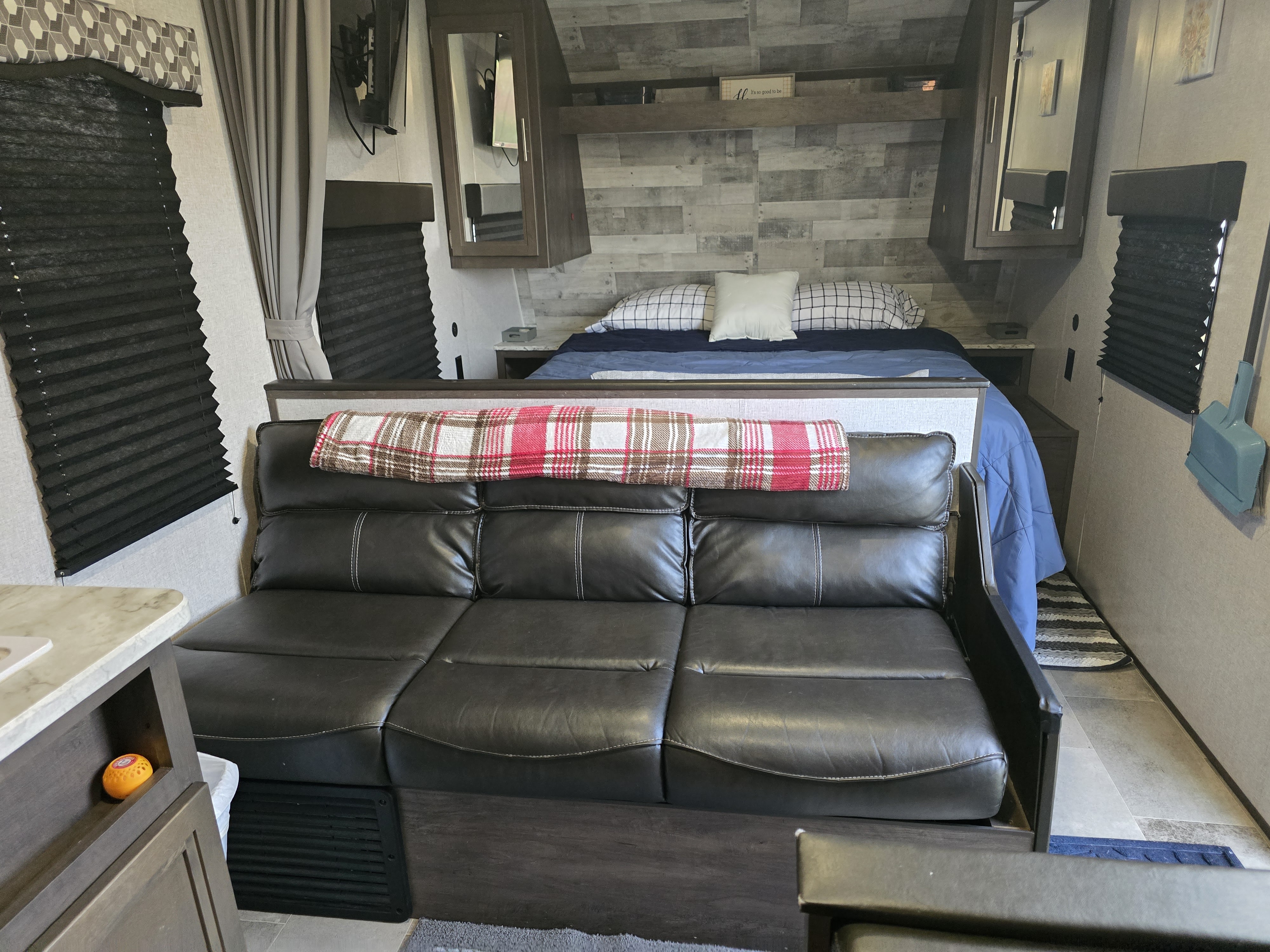 RV rental interior showcasing a comfortable sofa, queen bed, and practical built-in features.. Dutchmen Coleman Lantern 2020