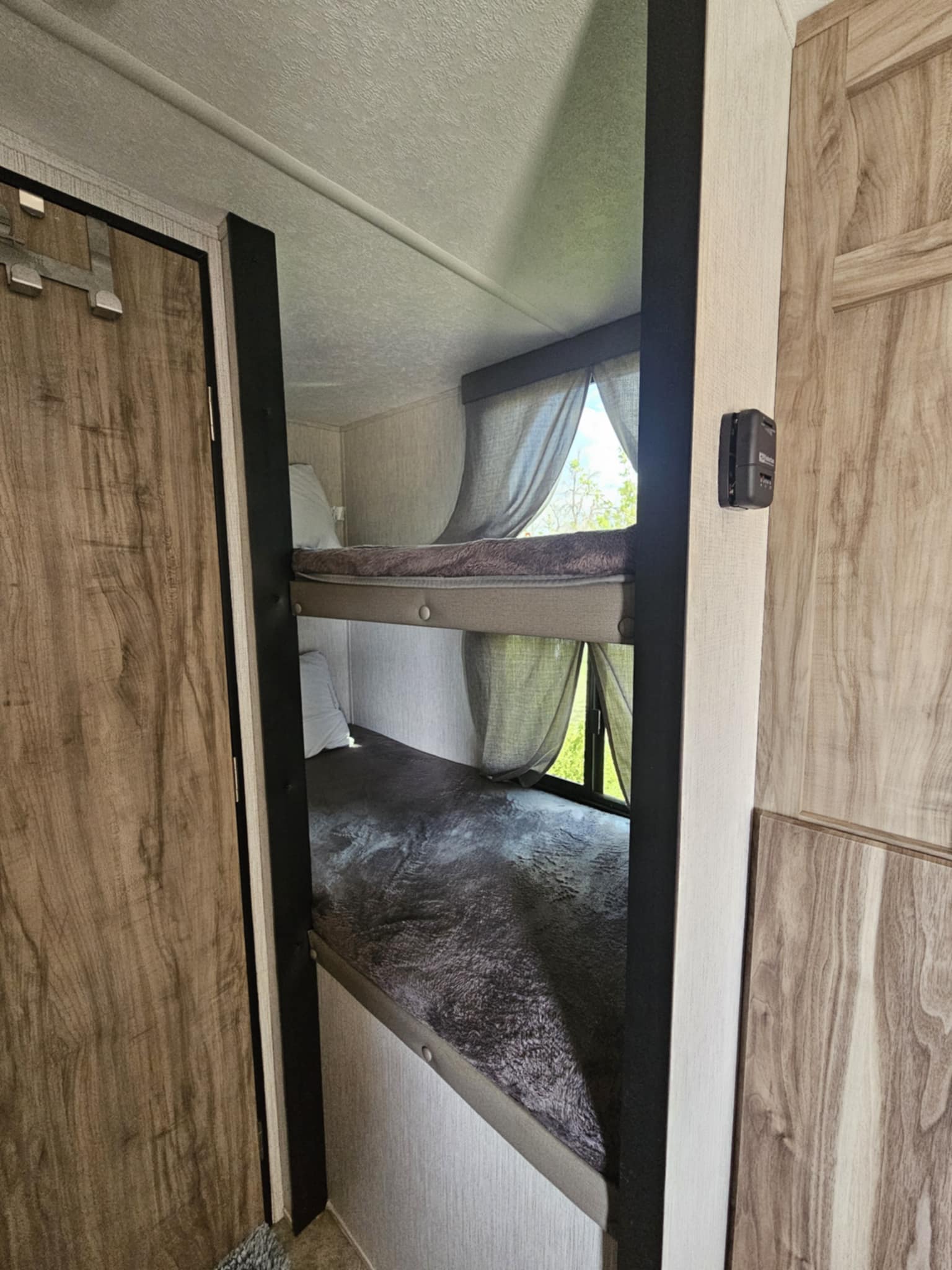Cozy bunk beds in an RV rental, perfect for family camping adventures. Features comfortable sleeping and window views.. Palomino 189BHS 2022