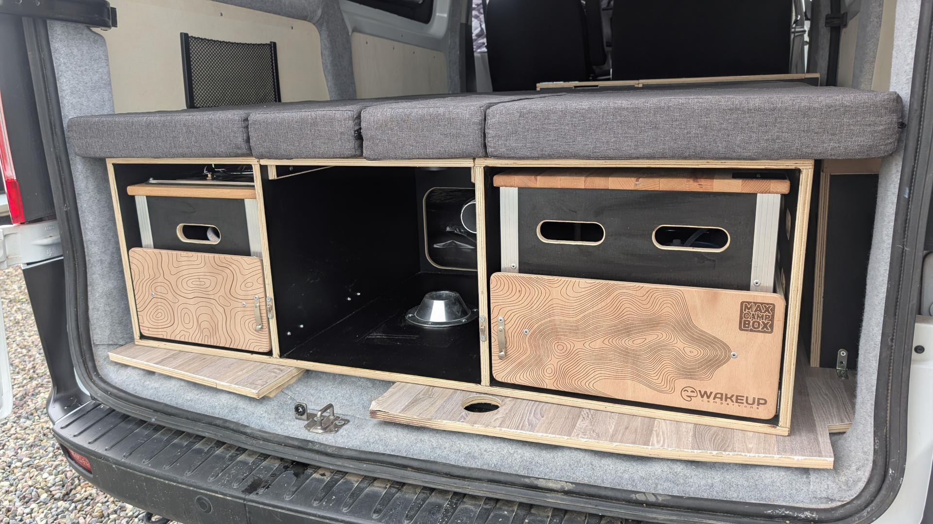 This RV rental shows a clever modular camper van interior with a bed, under-bed storage, and custom Max Camp Box.. Ford Transit Custom 2022