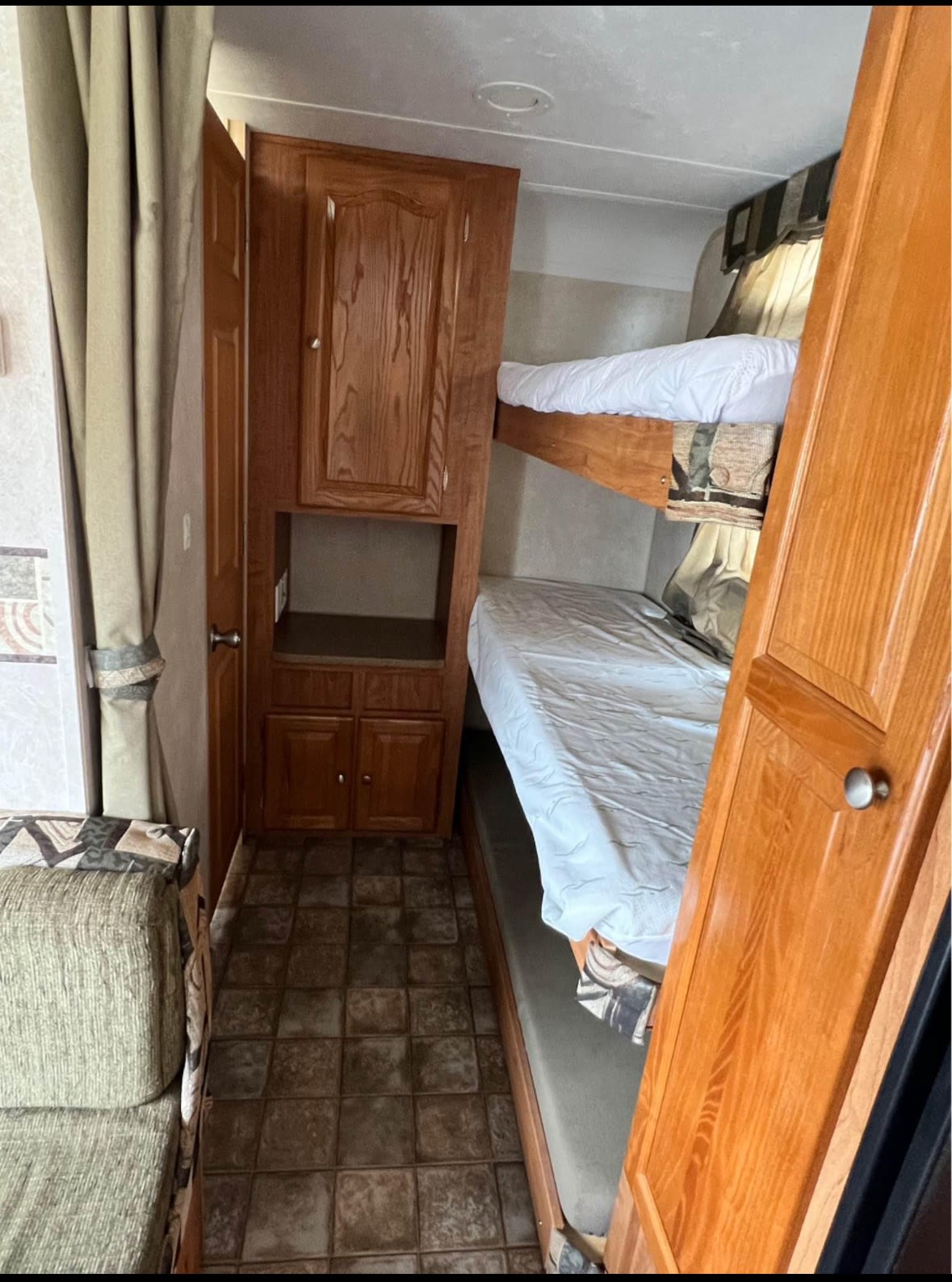 RV rental interior: cozy sleeping area with two bunk beds, wooden storage cabinets, and a tiled floor for comfort.. Flagstaff Super Lite 2008