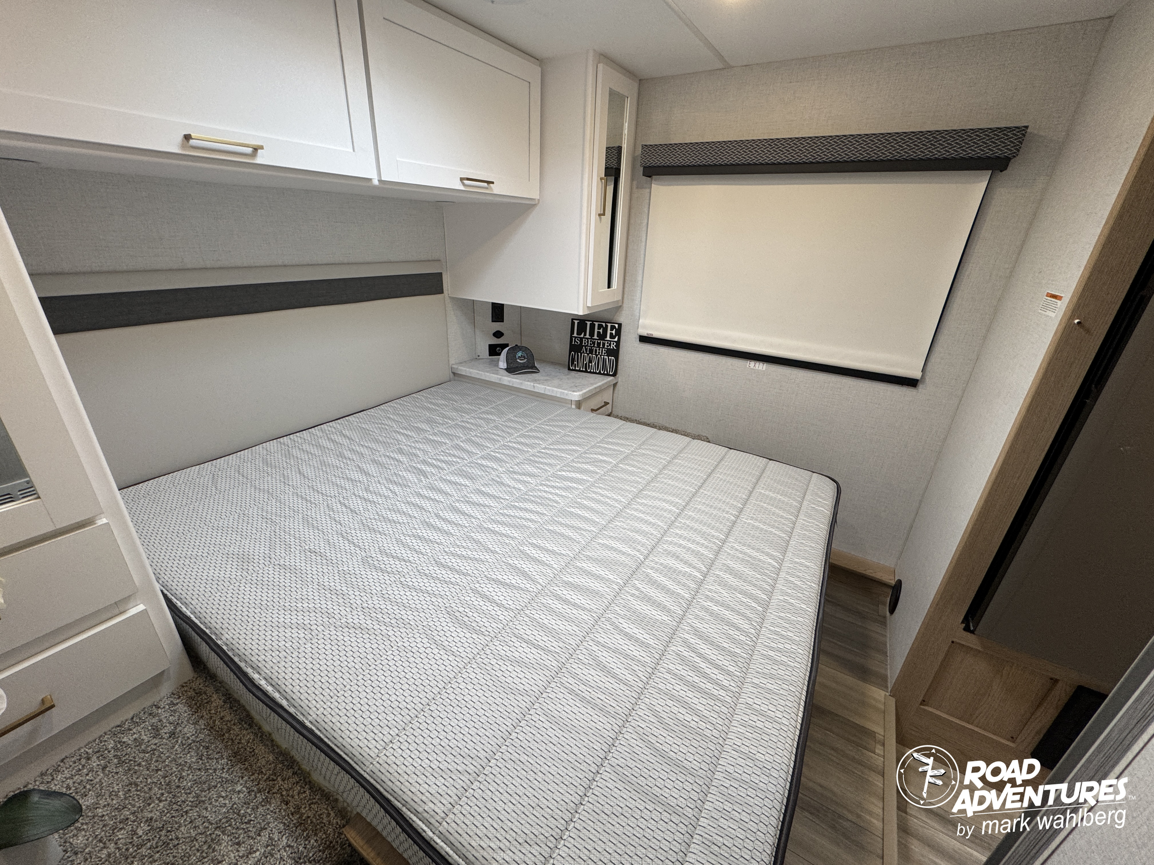 This RV rental offers a compact, inviting bedroom with a comfortable bed, cabinets, and a window.. Thor Motor Coach Four Winds 28Z 2026