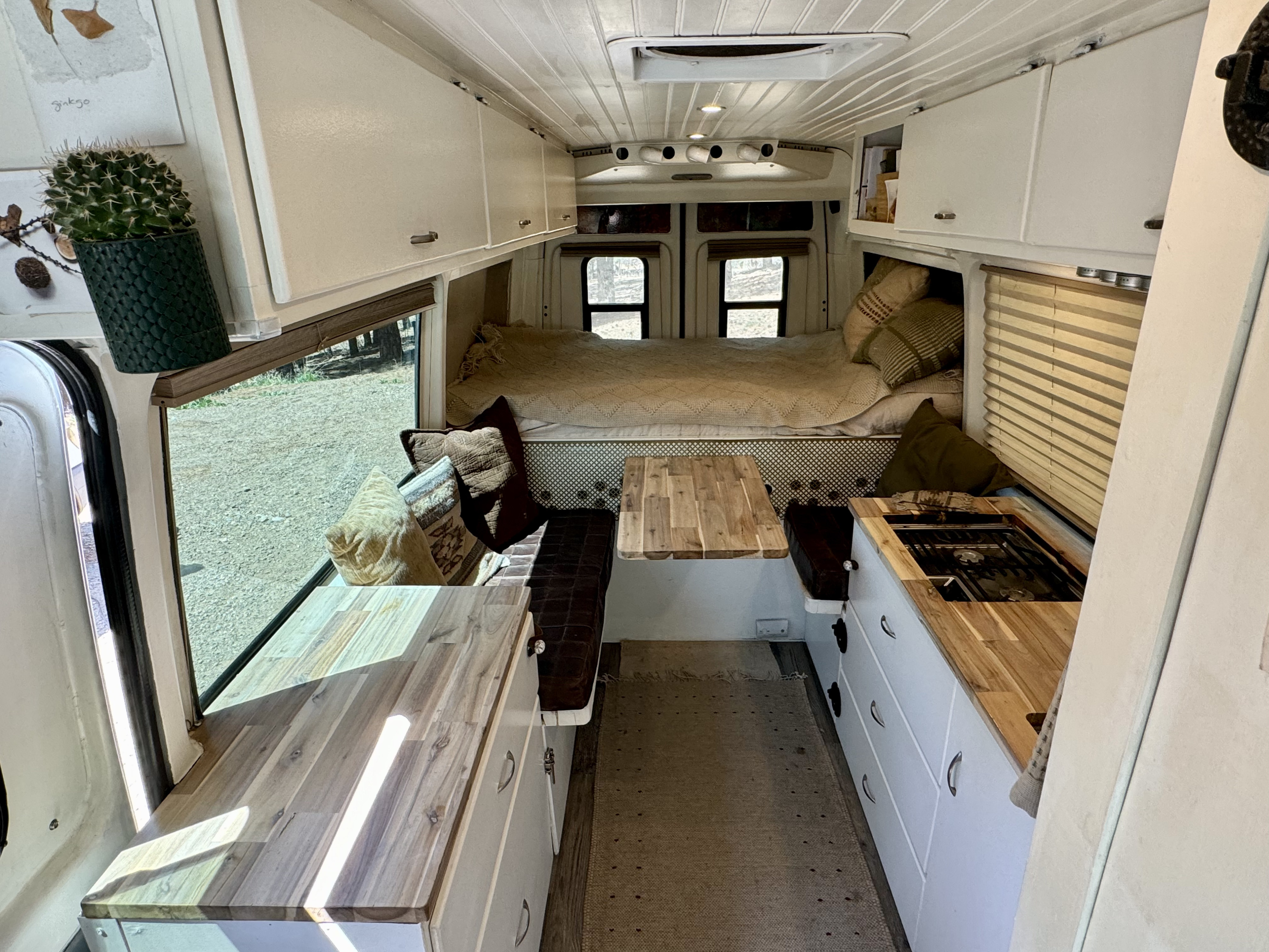 Bright camper van RV rental interior: kitchen, bed, and dining area. A cozy mobile living space.. Dodge Sprinter 2500 170ext 2006