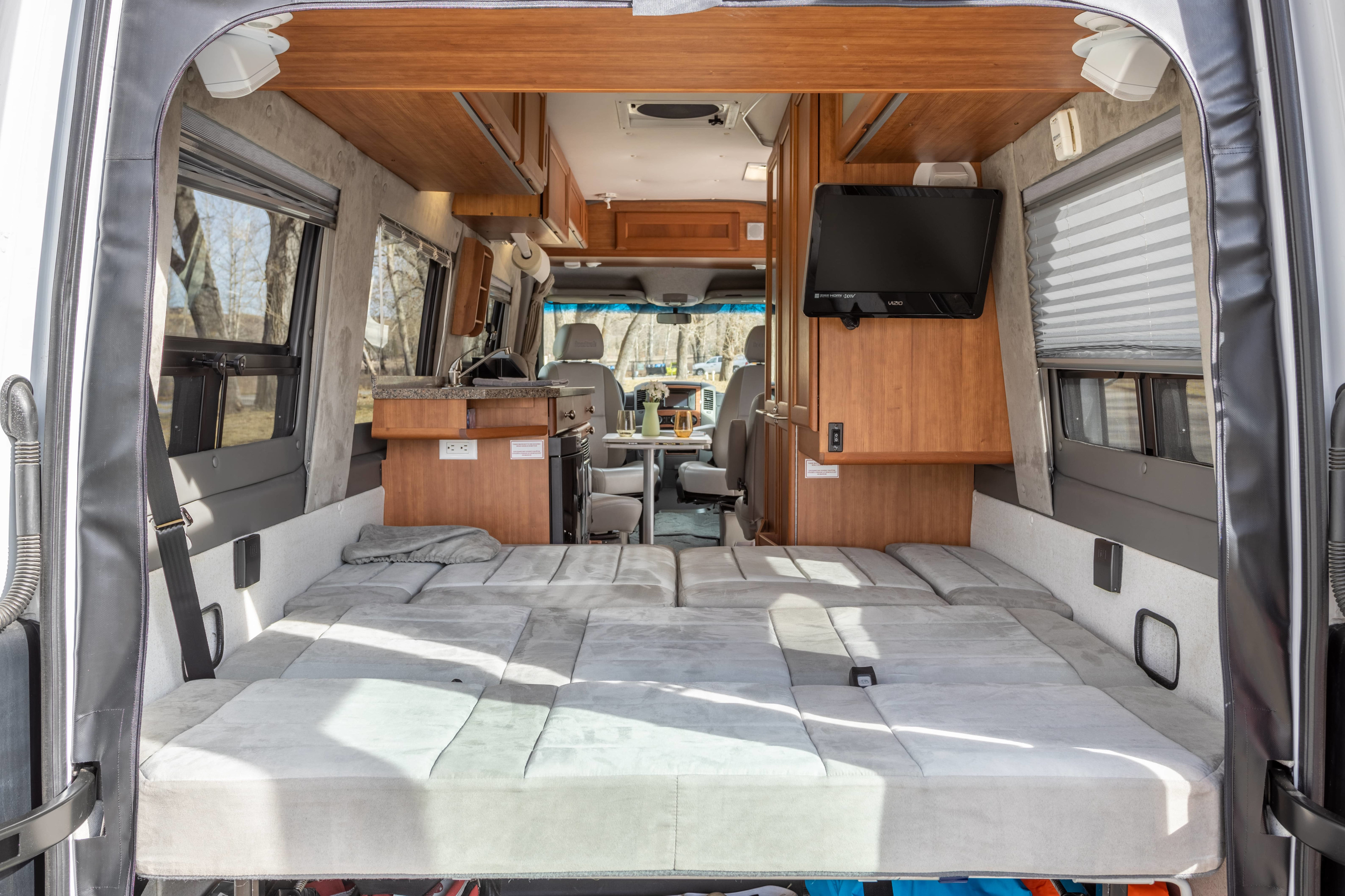 Inside this RV rental: a plush convertible bed, compact kitchen, dining area, and TV. Ideal for road trips.. Roadtrek Roadtrek Class B 2010
