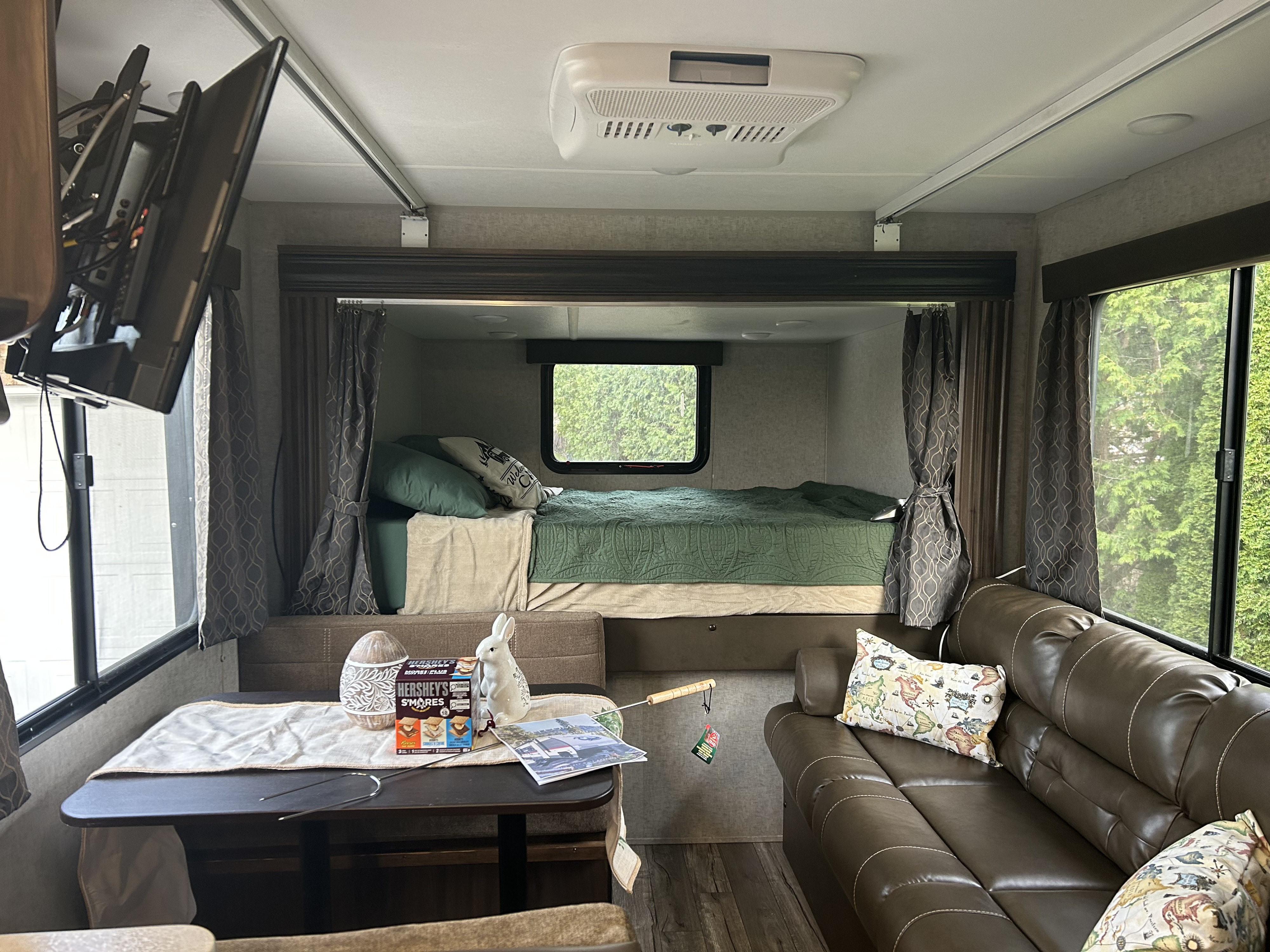 Spacious RV rental interior featuring a cozy living area with sofa, dining table, and comfortable bunk bed. Perfect for your next adventure.. Forest River Cherokee Grey Wolf 2019