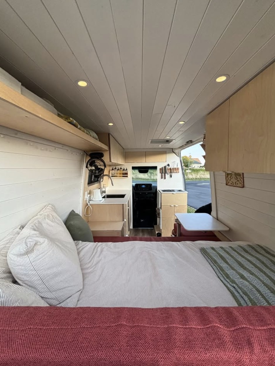 RV rental: Interior of a bright van conversion with a large bed, kitchenette, and smart storage.. Mercedes Benz Sprinter 144 Diesel 2023