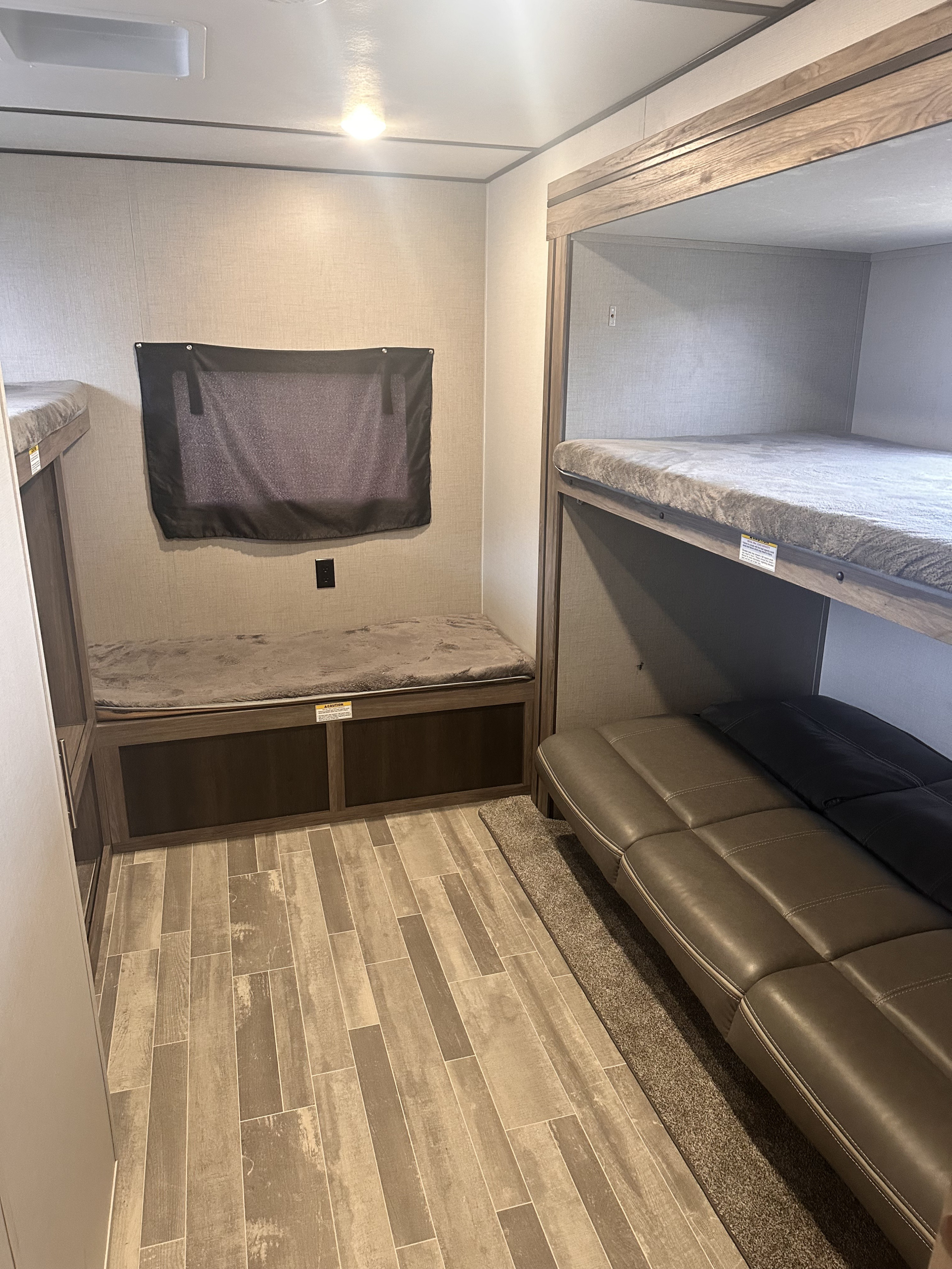 RV rental interior: cozy bunk beds, a versatile convertible sofa, and bench seating. Practical living space for travelers.. Crossroads RV Zinger 2020