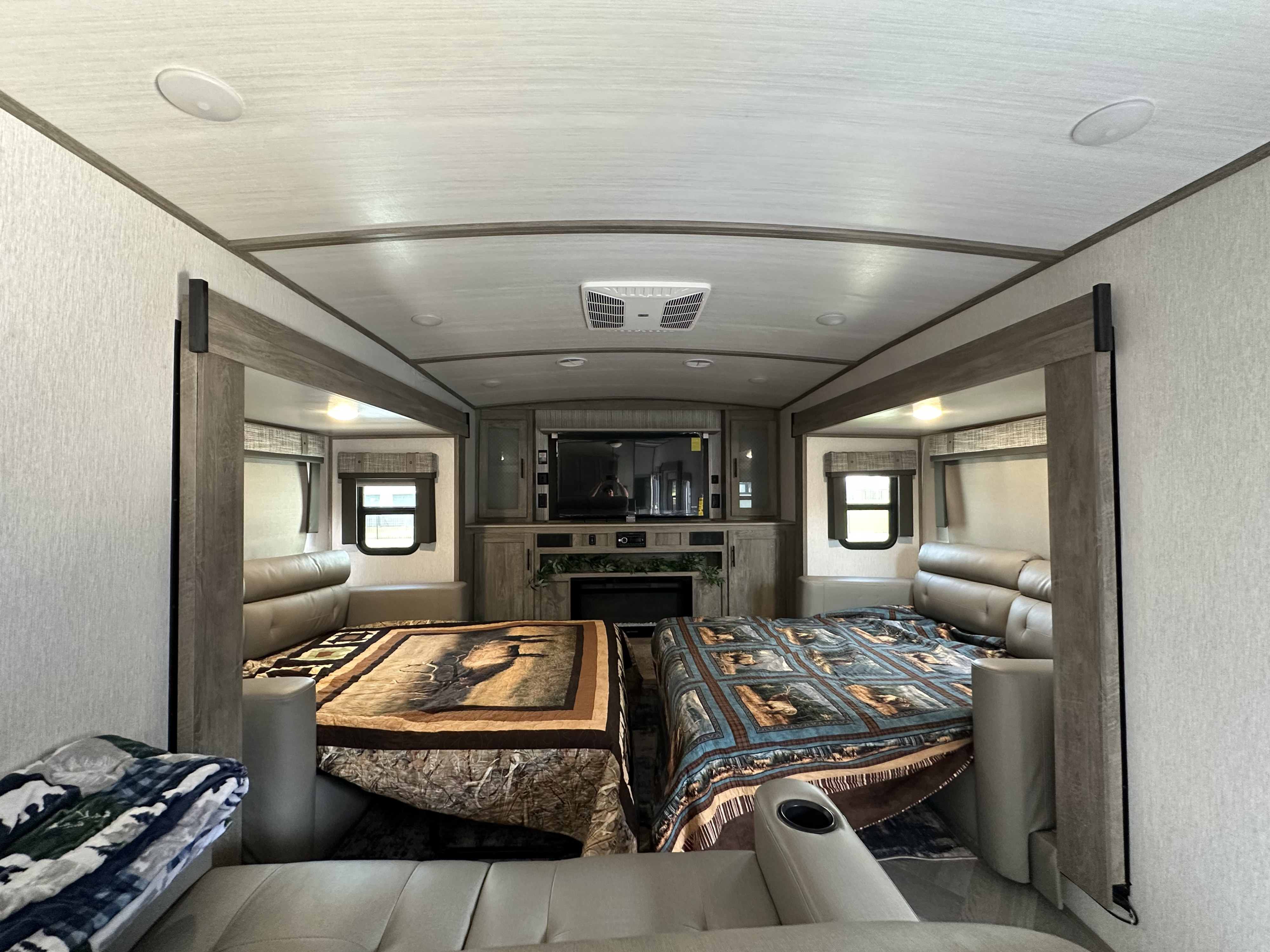 Spacious RV rental interior featuring two large beds/lounges, a central entertainment area with TV, and fireplace.. Forest River Salem Hemisphere 2022