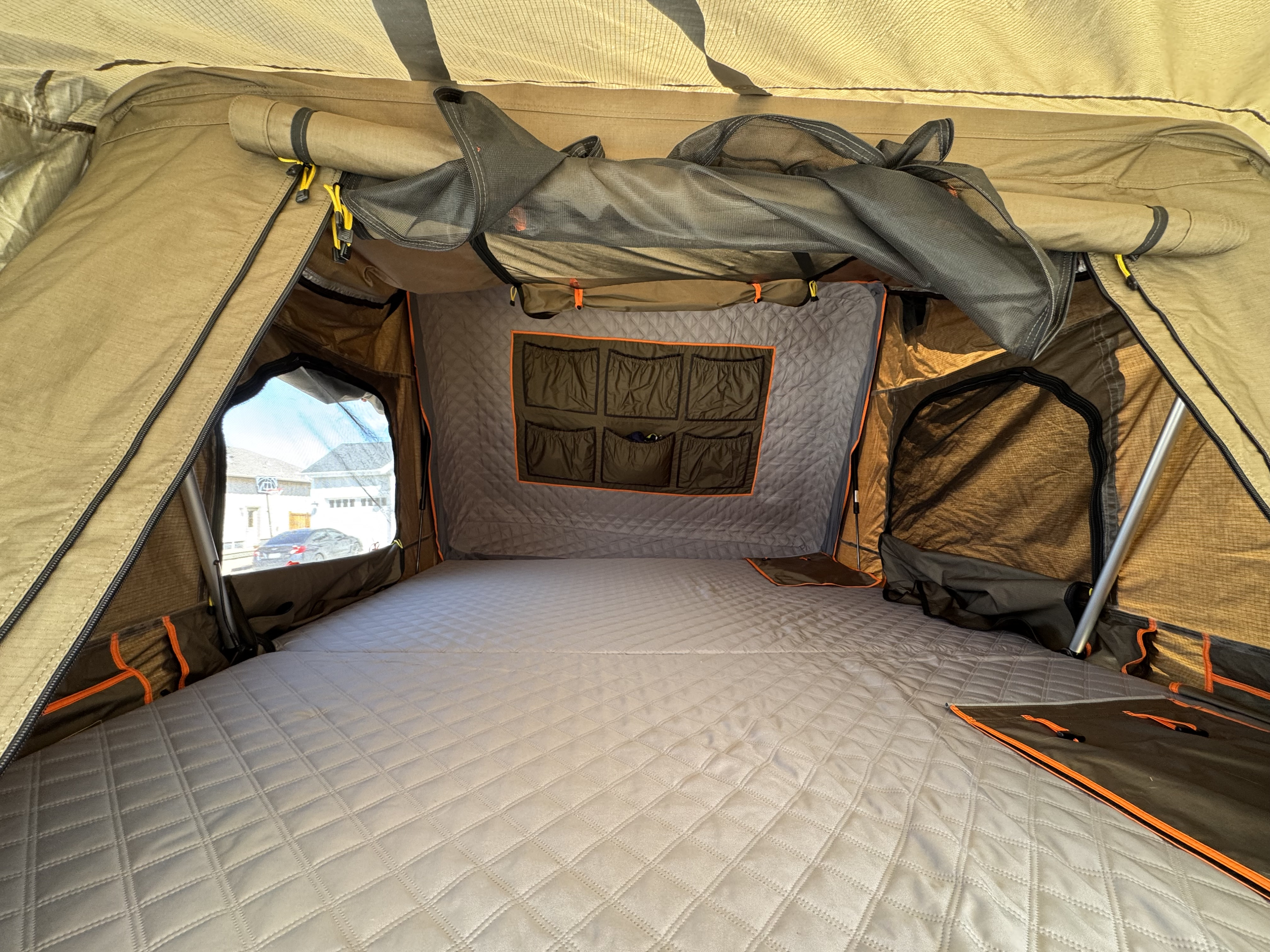 Spacious camping tent interior: quilted sleeping pad, window view, and storage pockets. Great for **RV rental** adventures.. Tribe Overland Basecamp/Expedition 2022