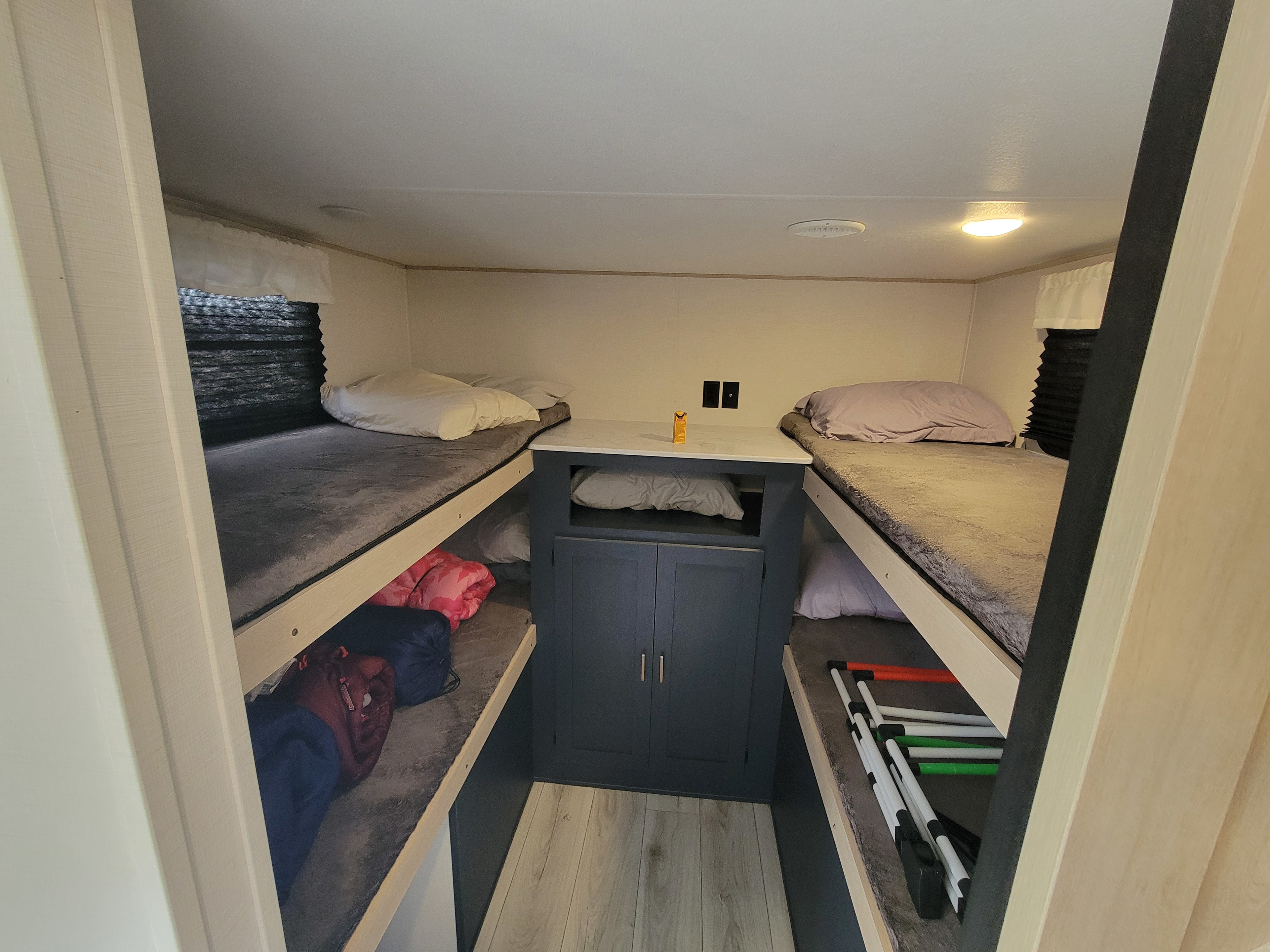 Inside an RV rental: practical bunk beds, central storage, and sleeping essentials for travelers.. Forest River Avenger Prime Time 2024